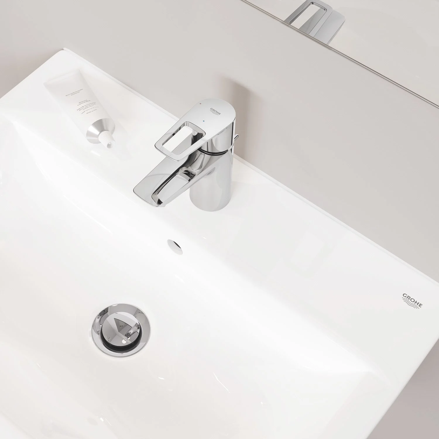 Chromowana bateria umywalkowa na białej umywalce, Grohe