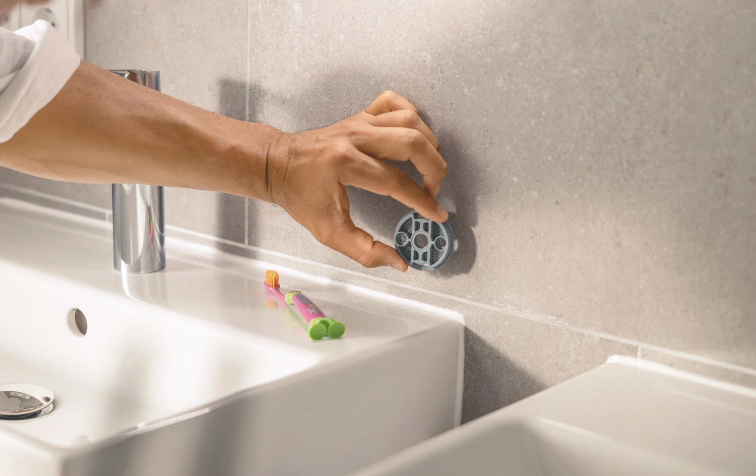 Ręka montuje uchwyt na ścianie łazienki, Grohe