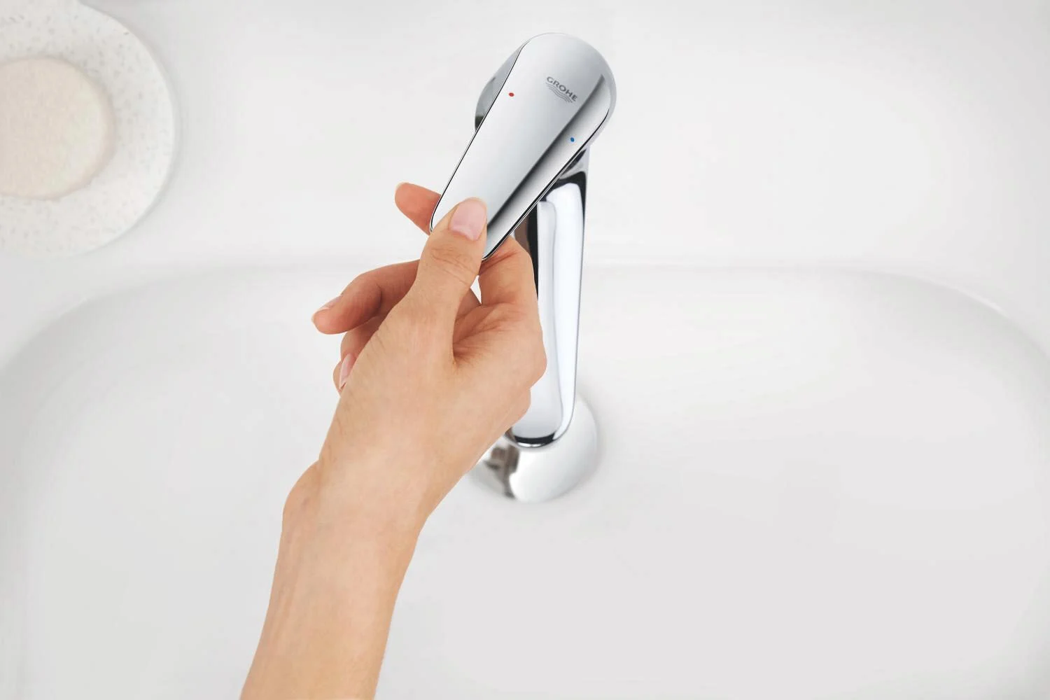 Ręka obsługuje baterię umywalkową z góry, Grohe