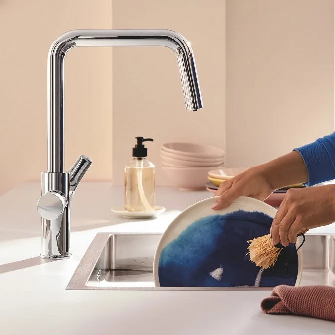Ręka płucząca talerz pod baterią kuchenną, Grohe