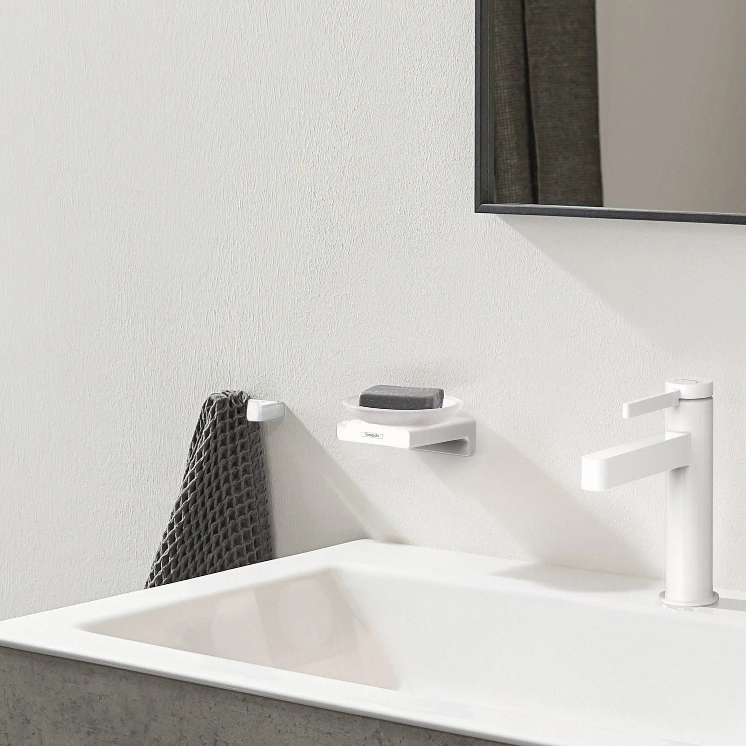Biała mydelniczka obok umywalki w łazience, hansgrohe