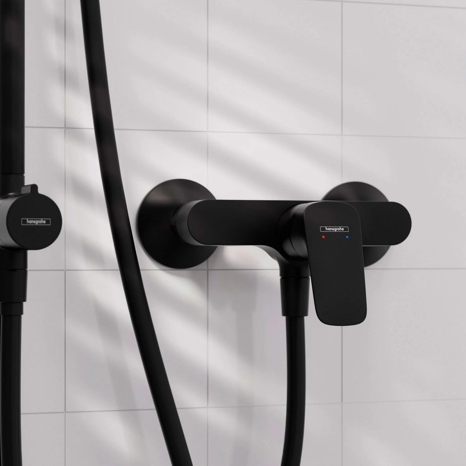 Czarna armatura prysznicowa na białej płytce, hansgrohe