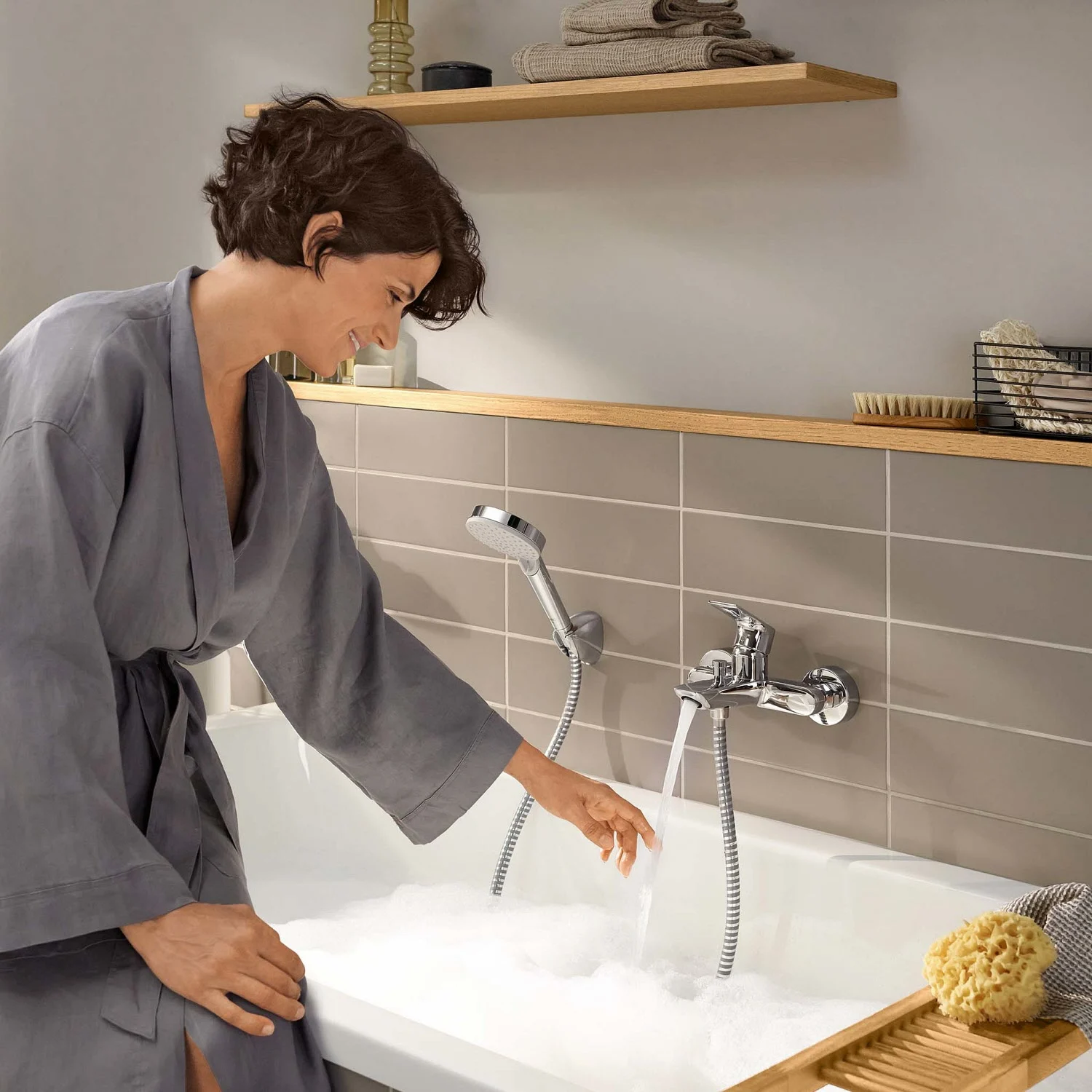 Kobieta napełnia wannę wodą z kranu, hansgrohe