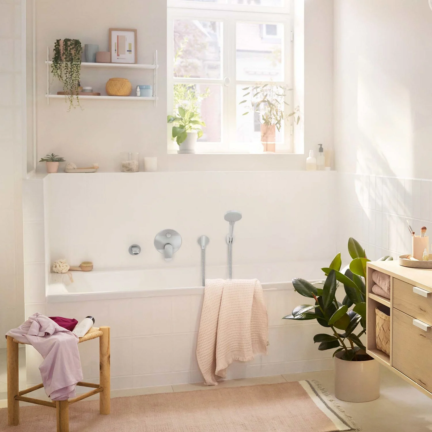 Jasna łazienka z wanną i ręcznikami, hansgrohe