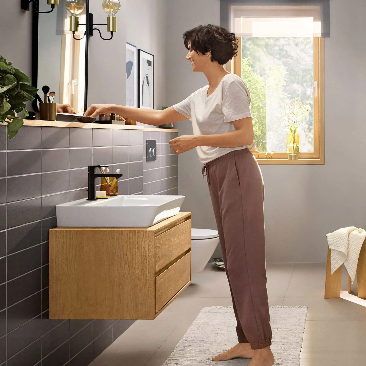 Kobieta w łazience z umywalką, hansgrohe