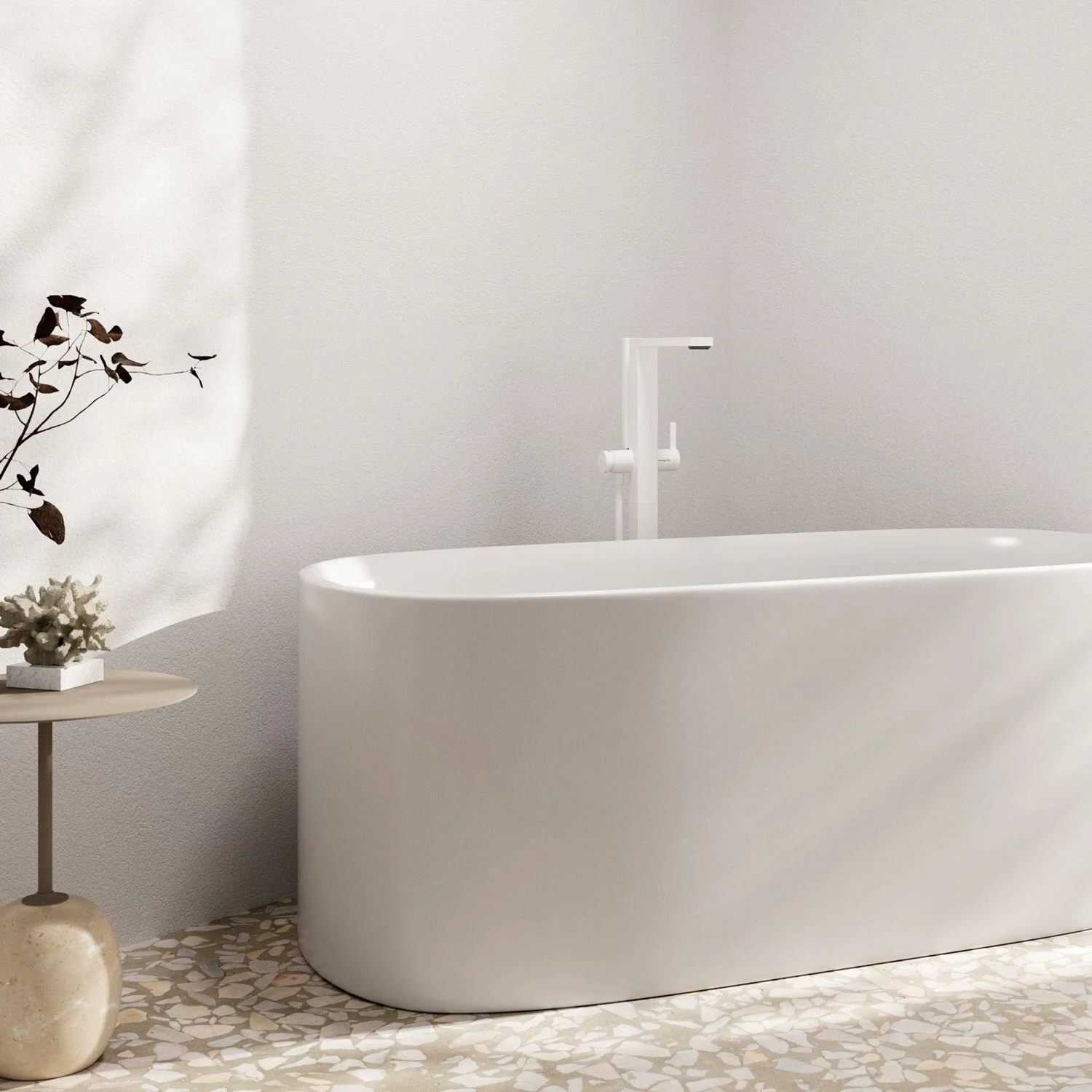 Biała wanna z kranem w jasnym pomieszczeniu, hansgrohe