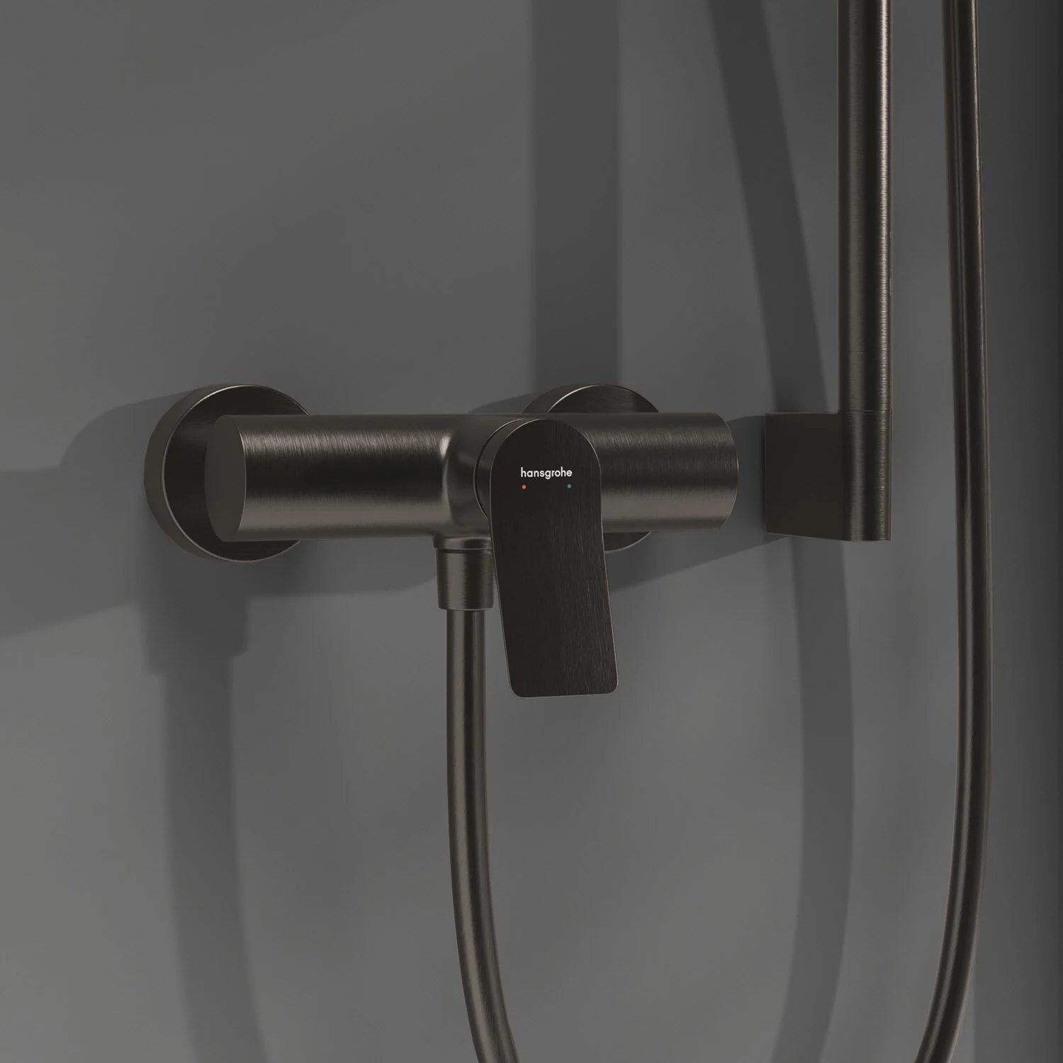 Czarna armatura prysznicowa zamontowana na szarej ścianie, hansgrohe
