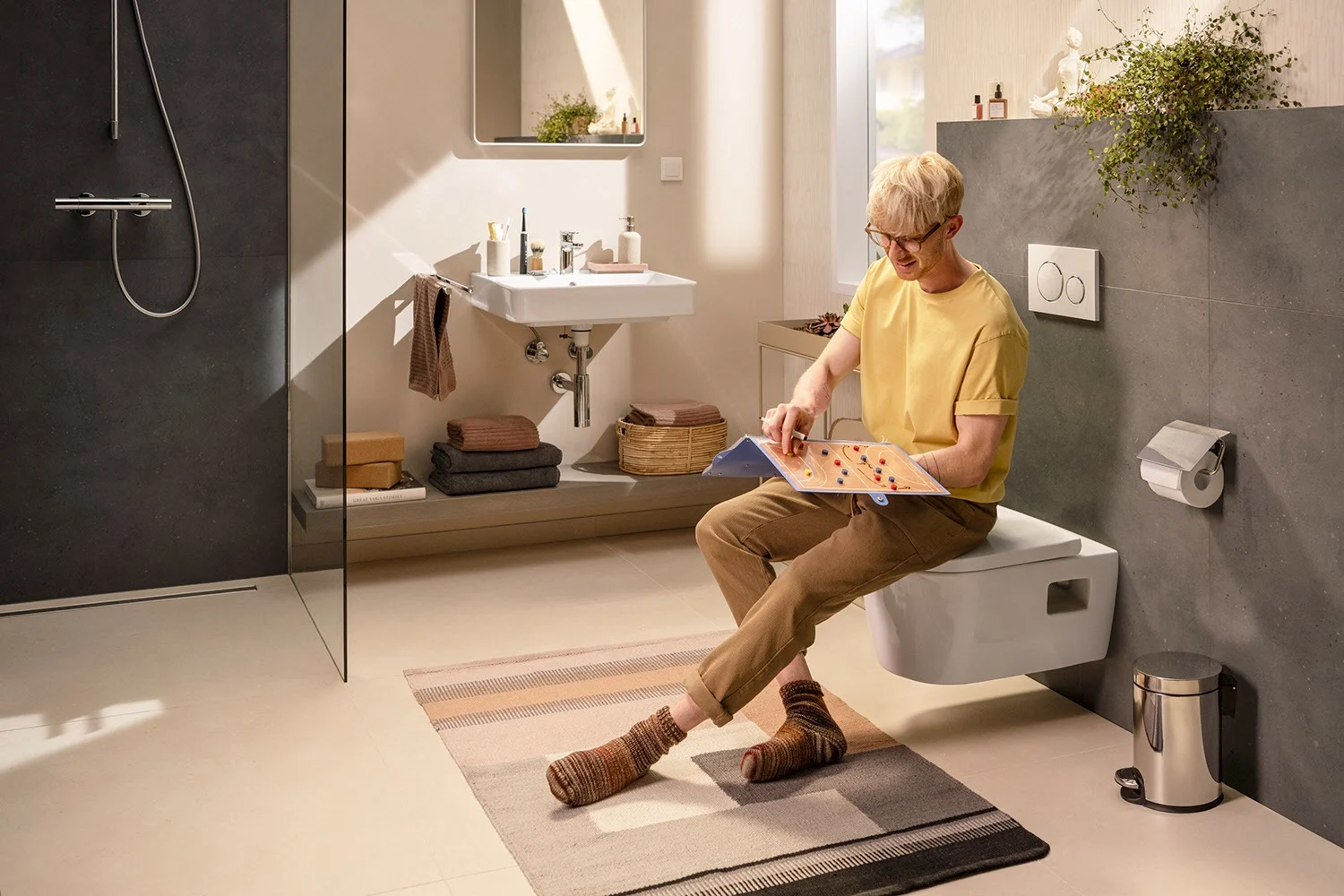 Osoba na toalecie podwieszanej w łazience, hansgrohe