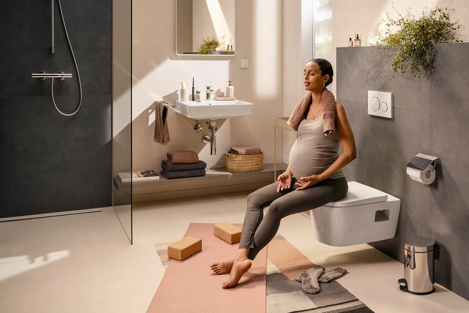 Kobieta w łazience z toaletą podwieszaną i umywalką, hansgrohe