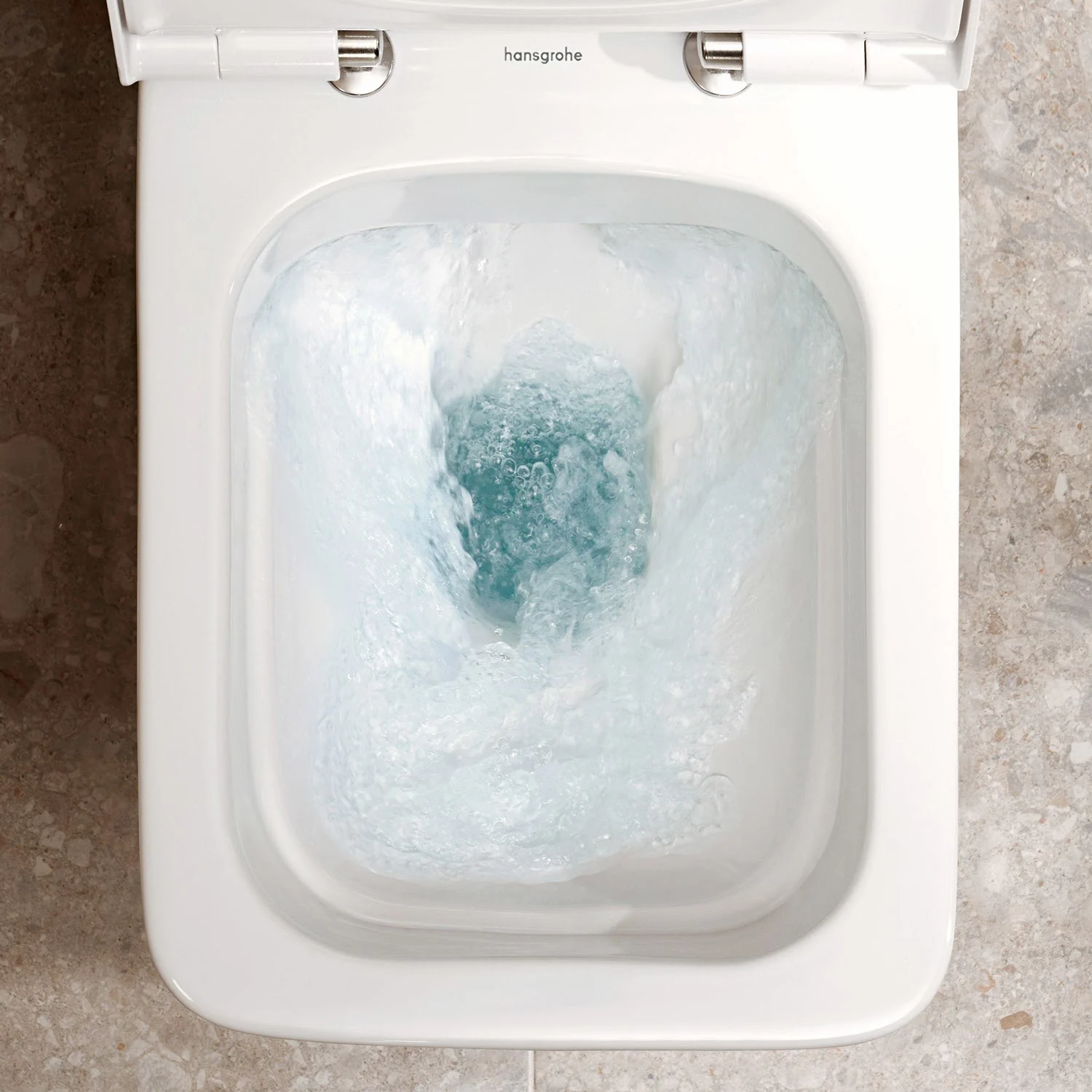Zbliżenie spłukującej się toalety stojącej, hansgrohe