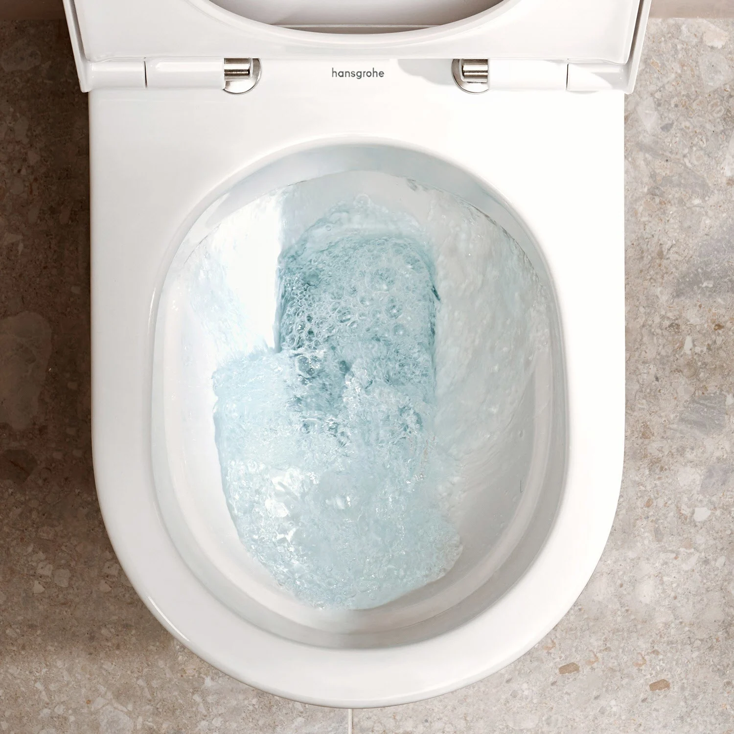 Zbliżenie spłukującej się toalety stojącej, hansgrohe