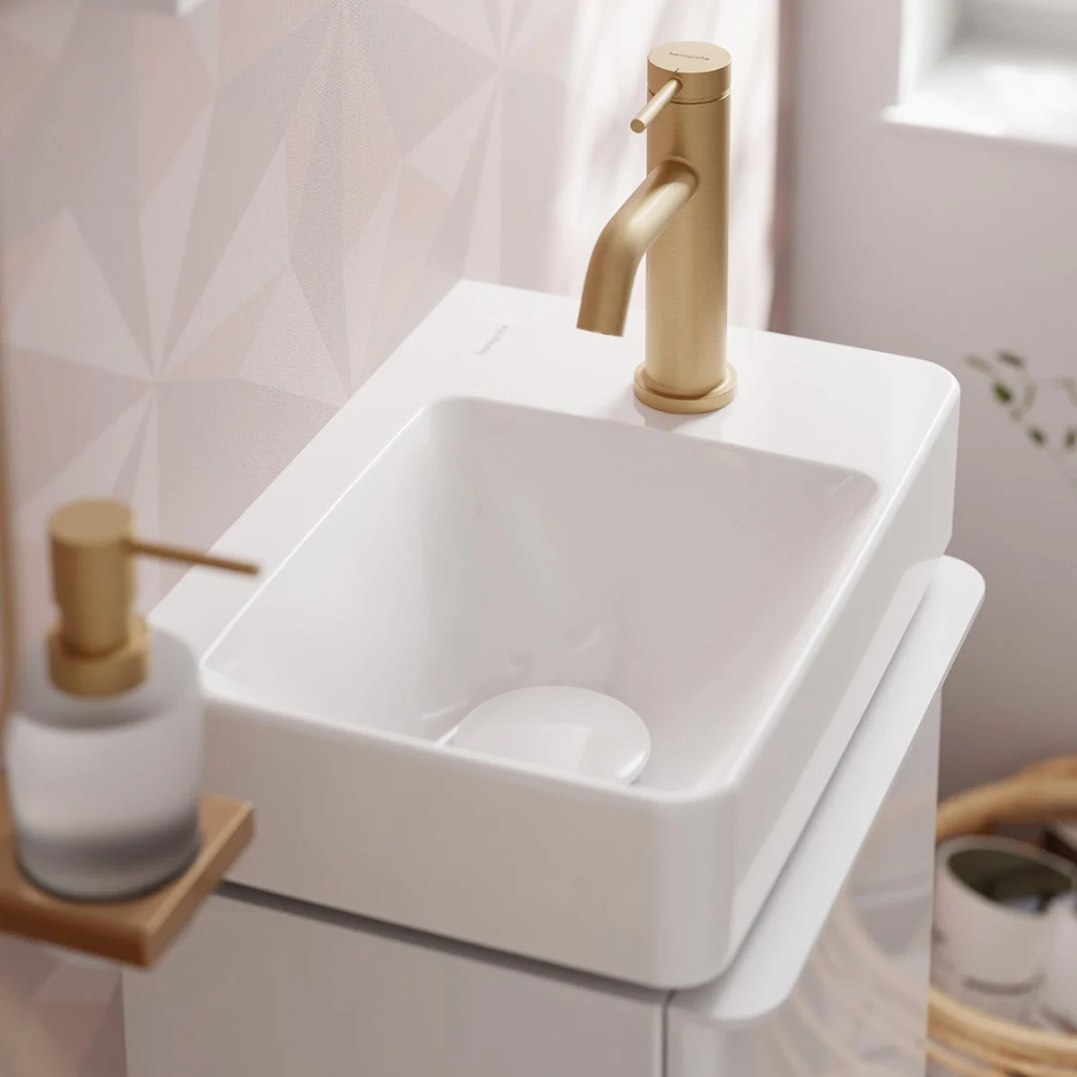 Biała umywalka z złotą baterią w łazience, hansgrohe