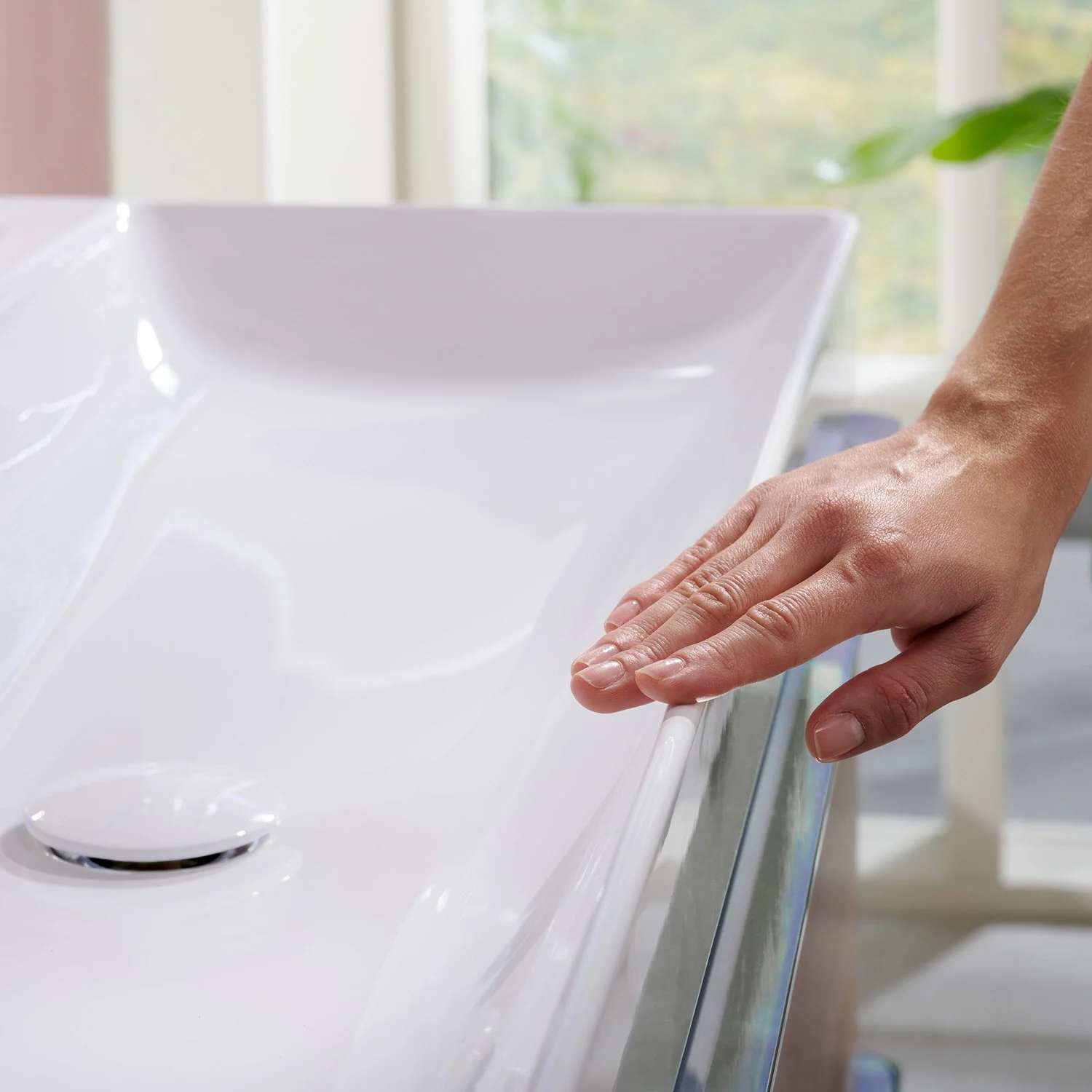 Zbliżenie białej umywalki z ręką, hansgrohe