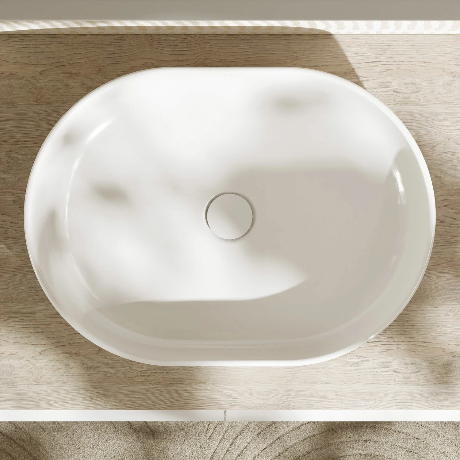 Owalna umywalka z góry na drewnianej powierzchni, hansgrohe