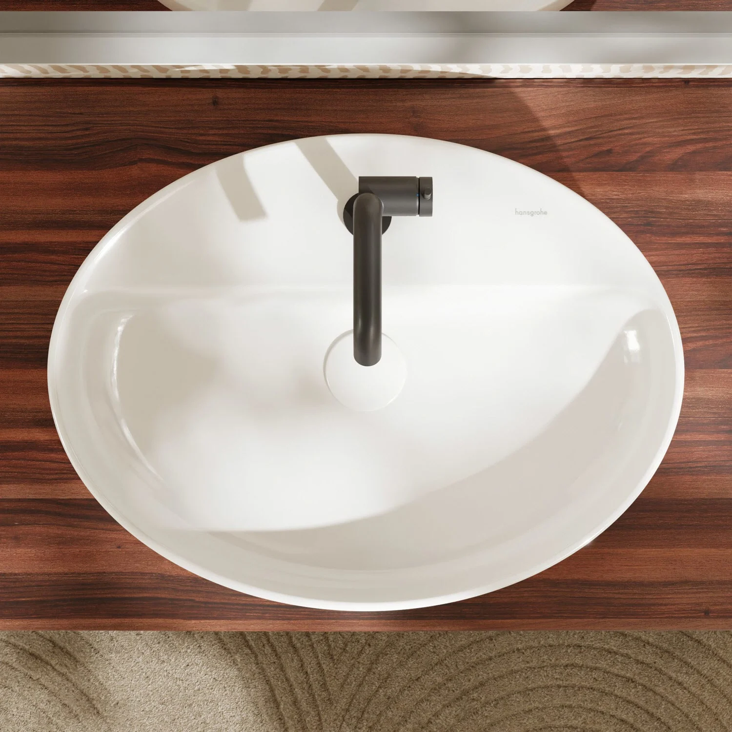 Owalna umywalka nablatowa zamontowana na drewnianej powierzchni, hansgrohe