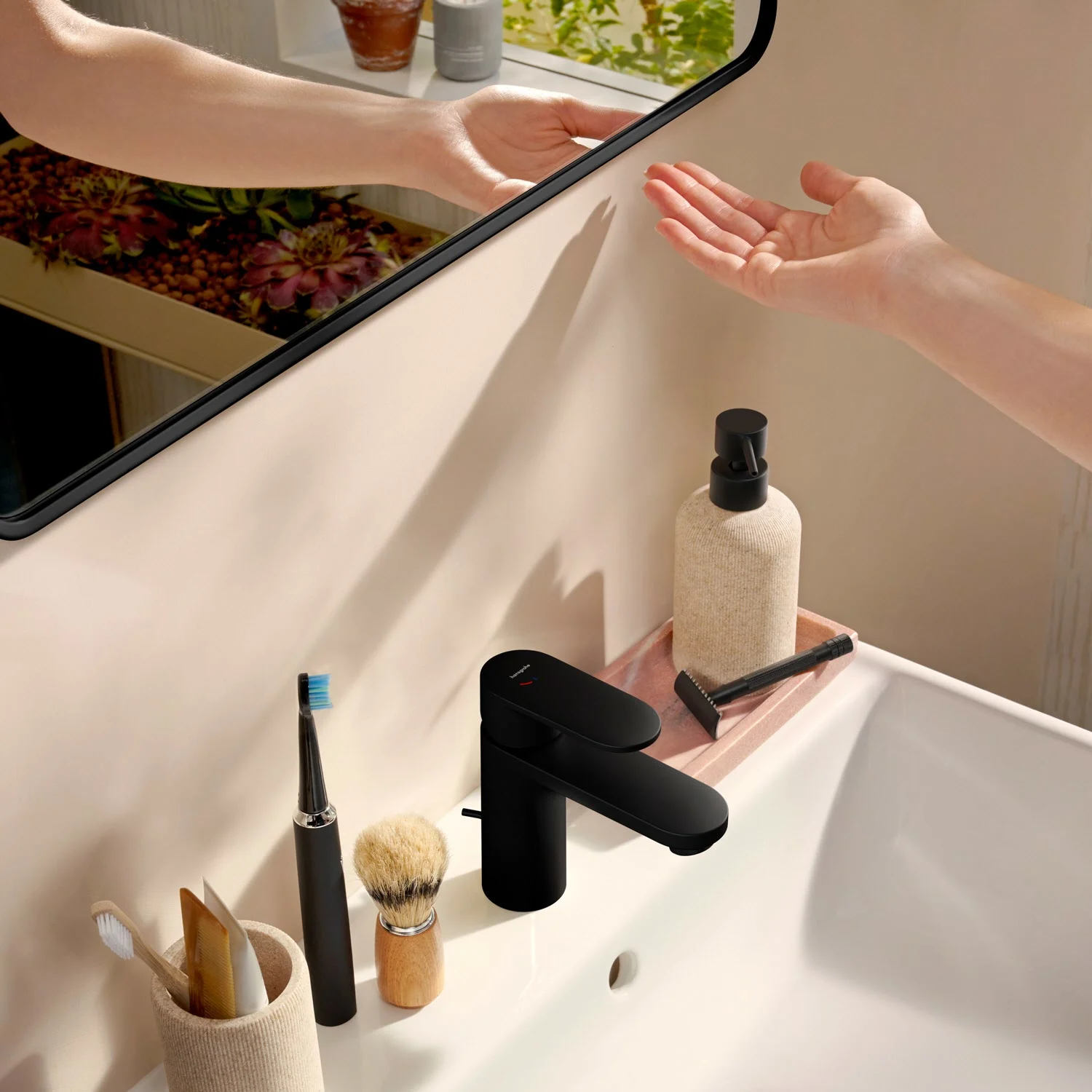 Umywalka z lustrem i ręką w łazience, hansgrohe