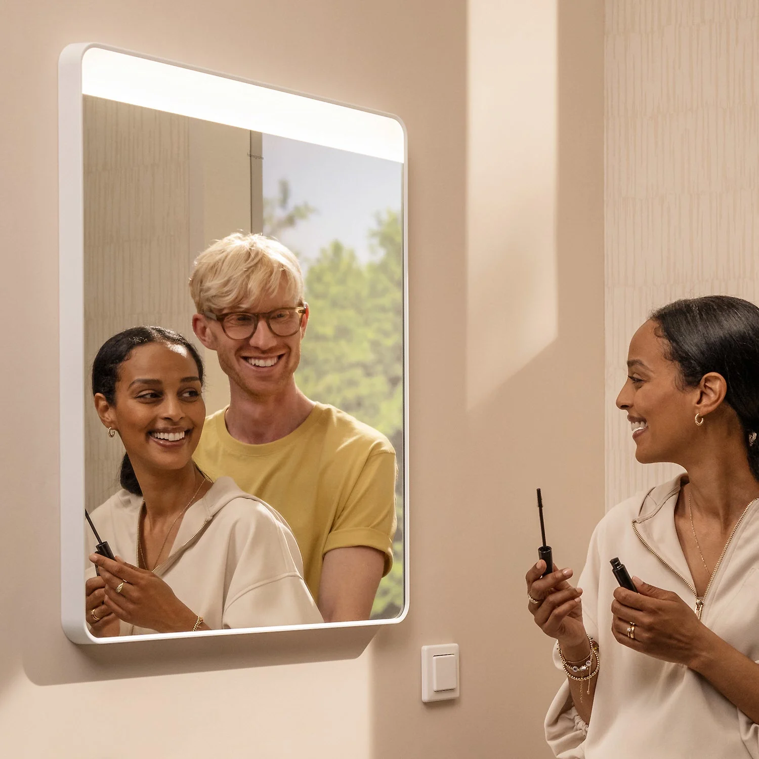 Para uśmiecha się przed podświetlanym lustrem, hansgrohe
