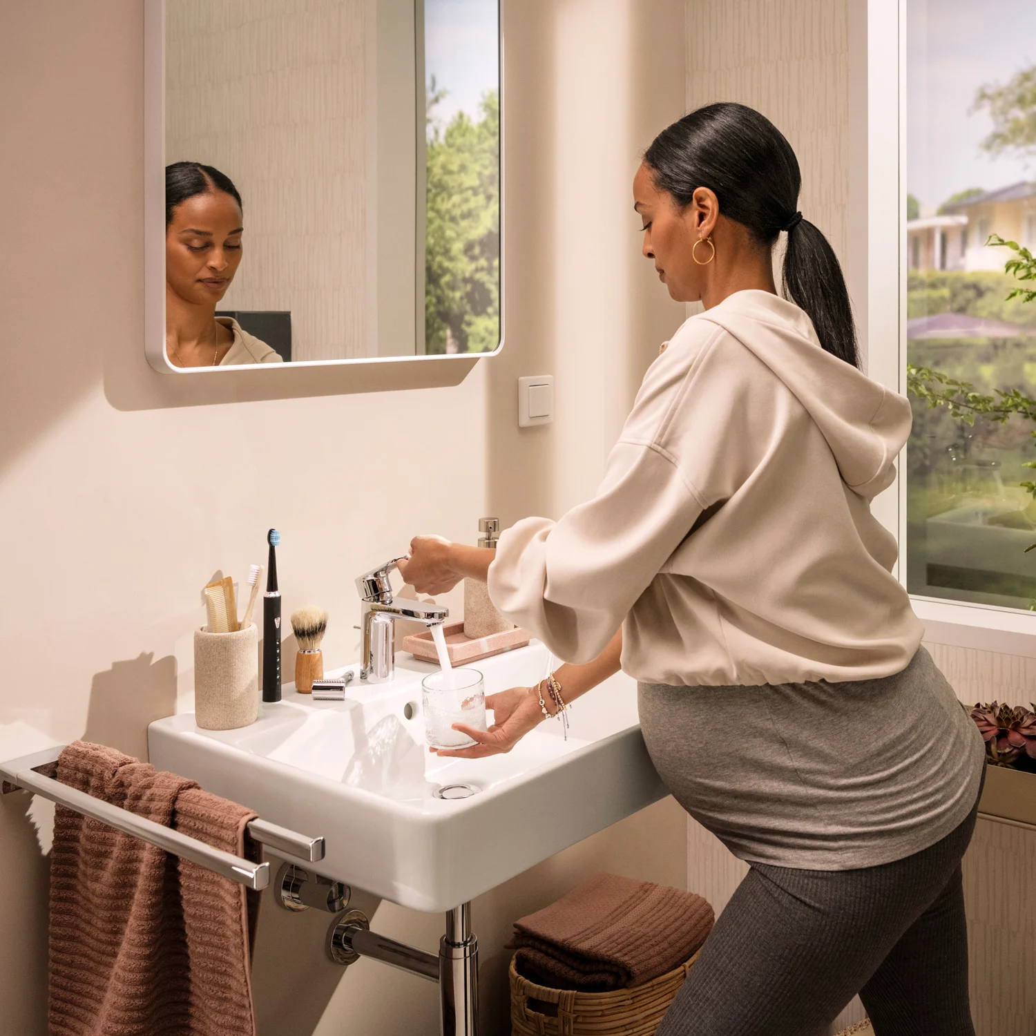 Kobieta używa umywalki w łazience, hansgrohe