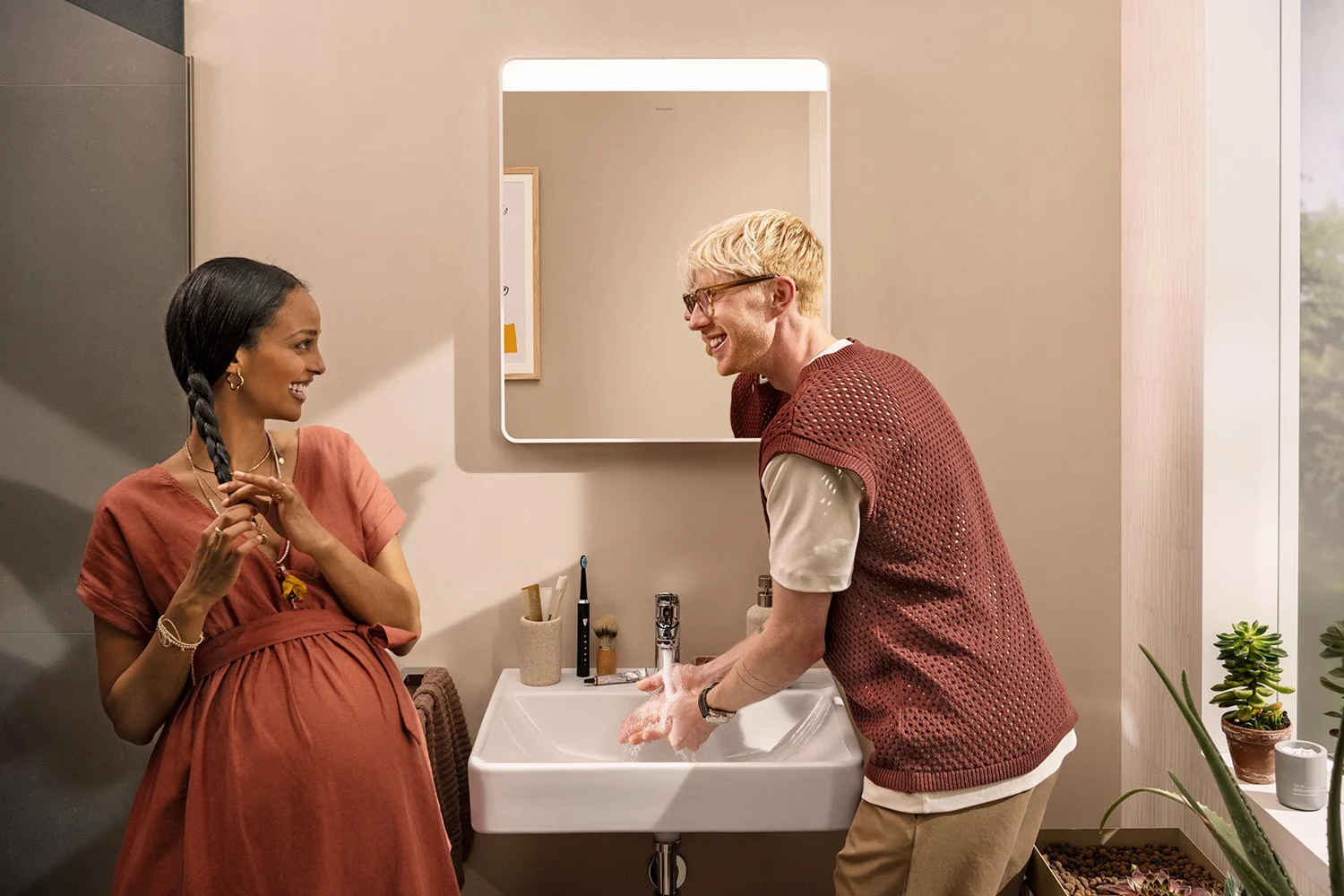 Dwie osoby w łazience przed lustrem, hansgrohe