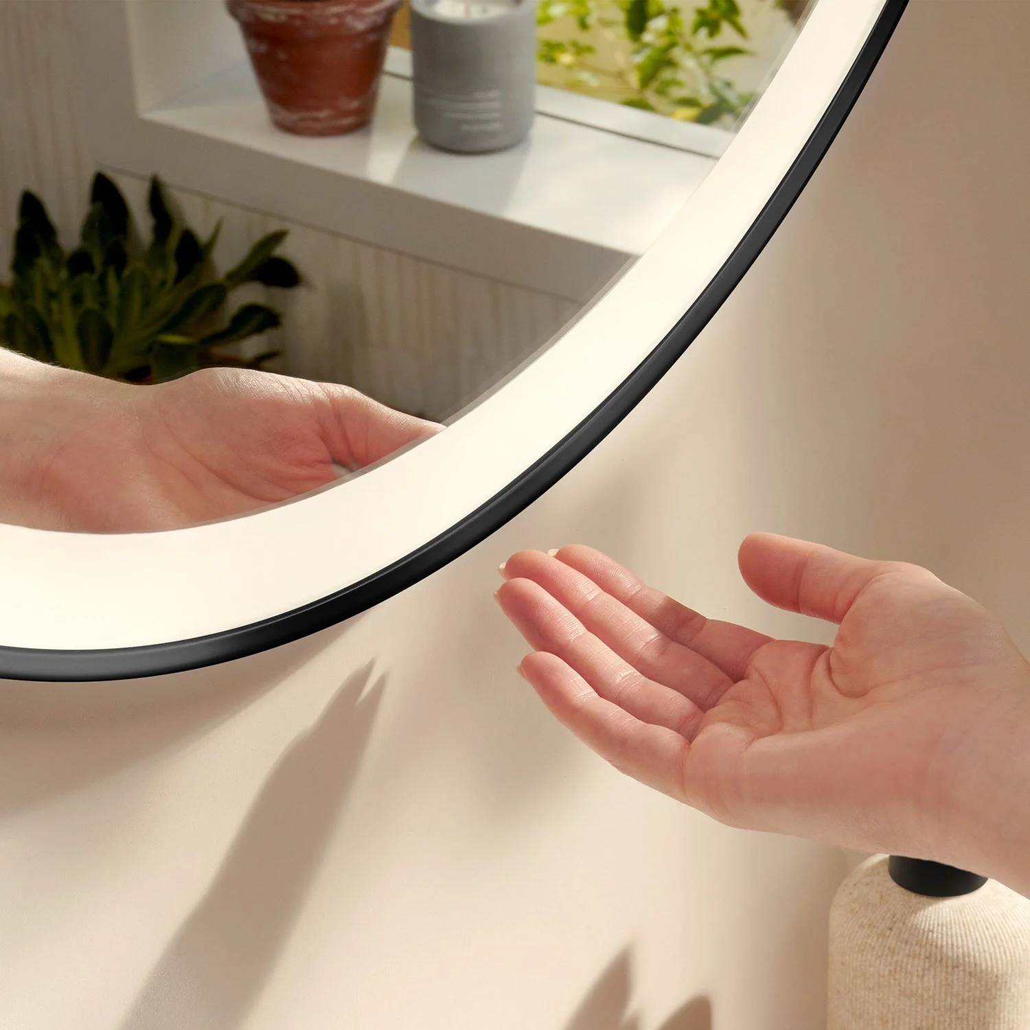 Okrągłe lustro z ręką w łazience, hansgrohe