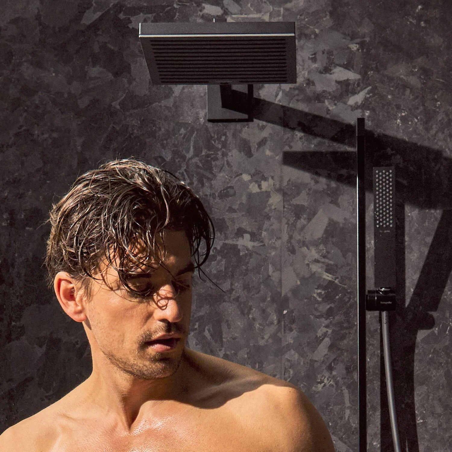 Osoba pod czarną deszczownicą w prysznicu, hansgrohe