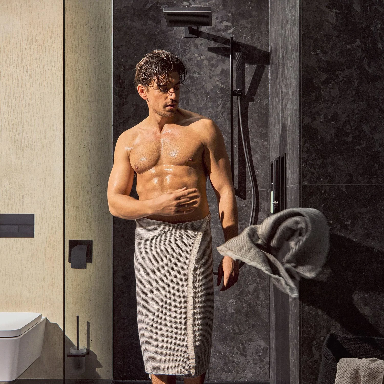 Mężczyzna pod prysznicem z prysznicem ręcznym, hansgrohe