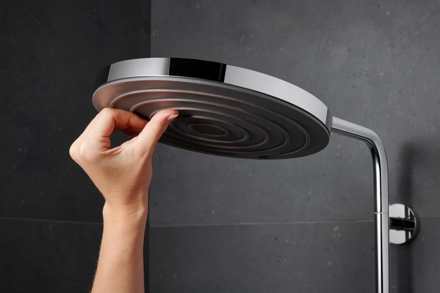 Ręka reguluje głowicę prysznicową z bliska, hansgrohe
