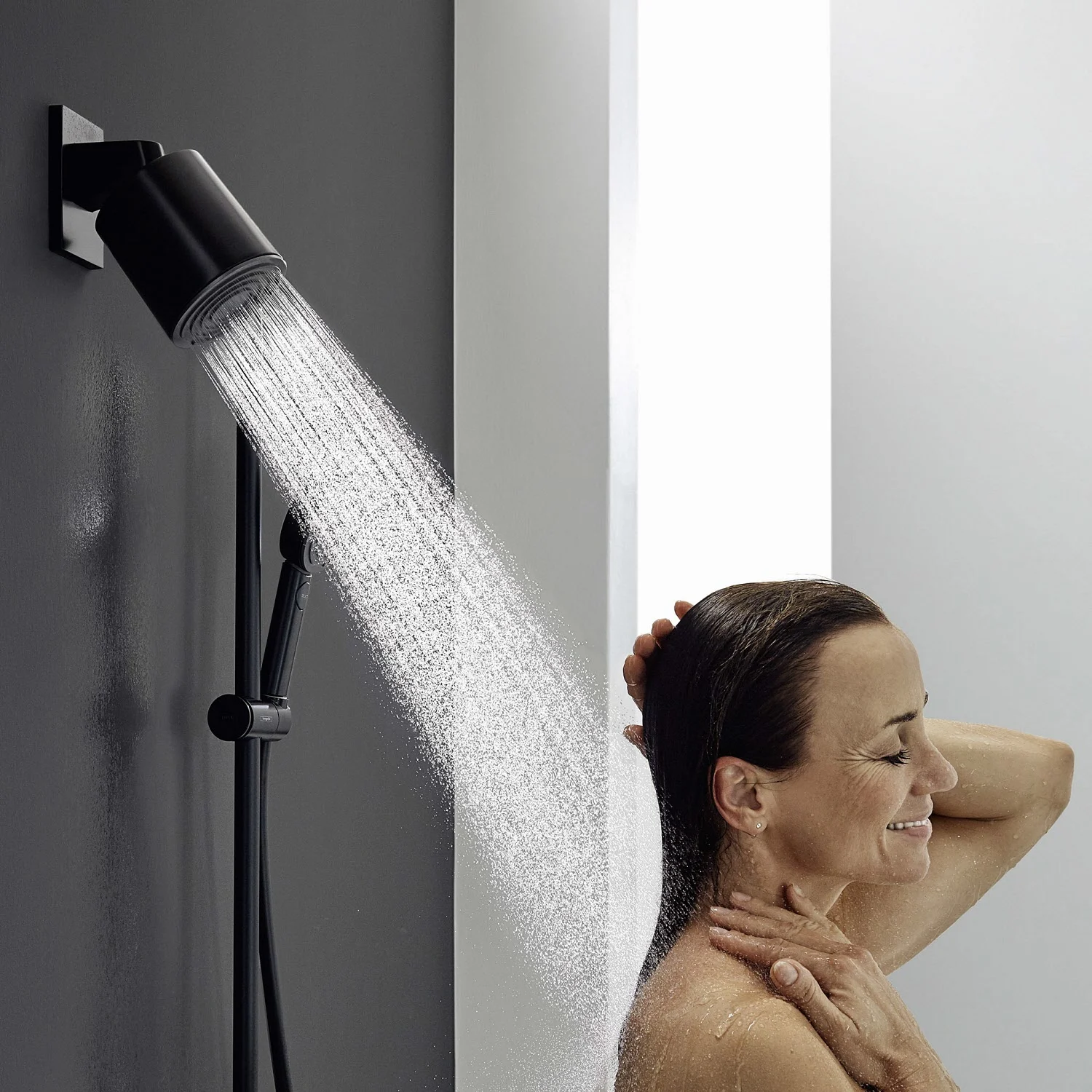 Kobieta pod prysznicem z czarną słuchawką, hansgrohe