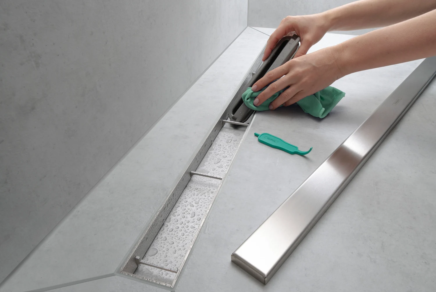 Czyszczenie odpływu prysznicowego zieloną szmatką zbliżenie, hansgrohe