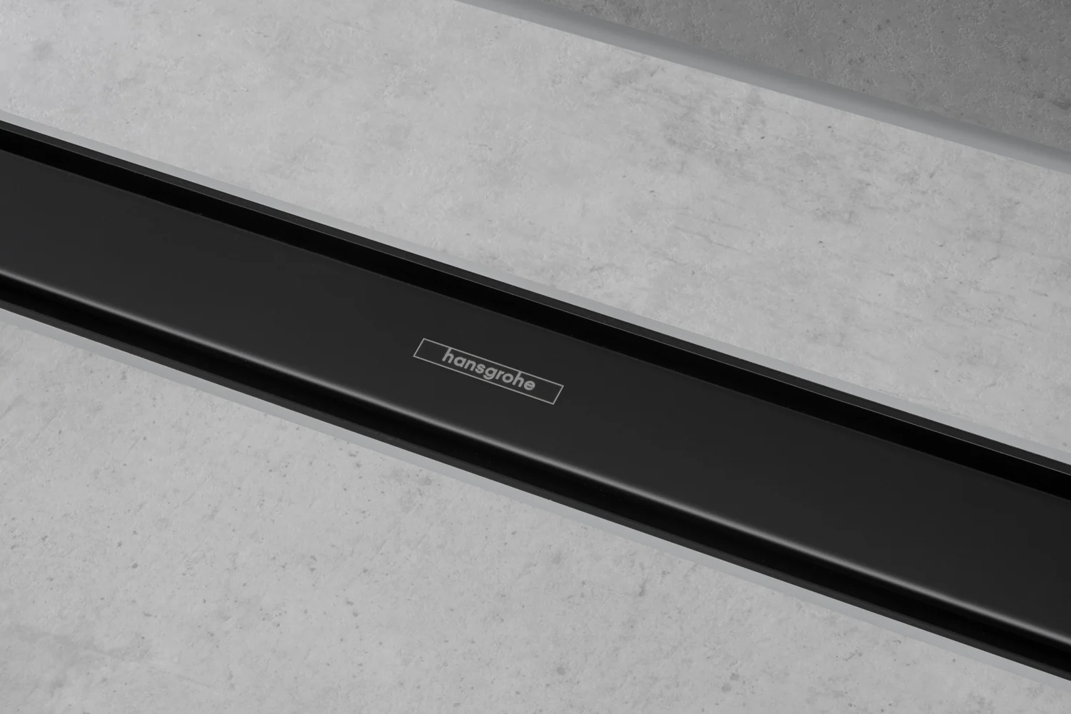 Zbliżenie czarnego odpływu prysznicowego na szarej podłodze, hansgrohe