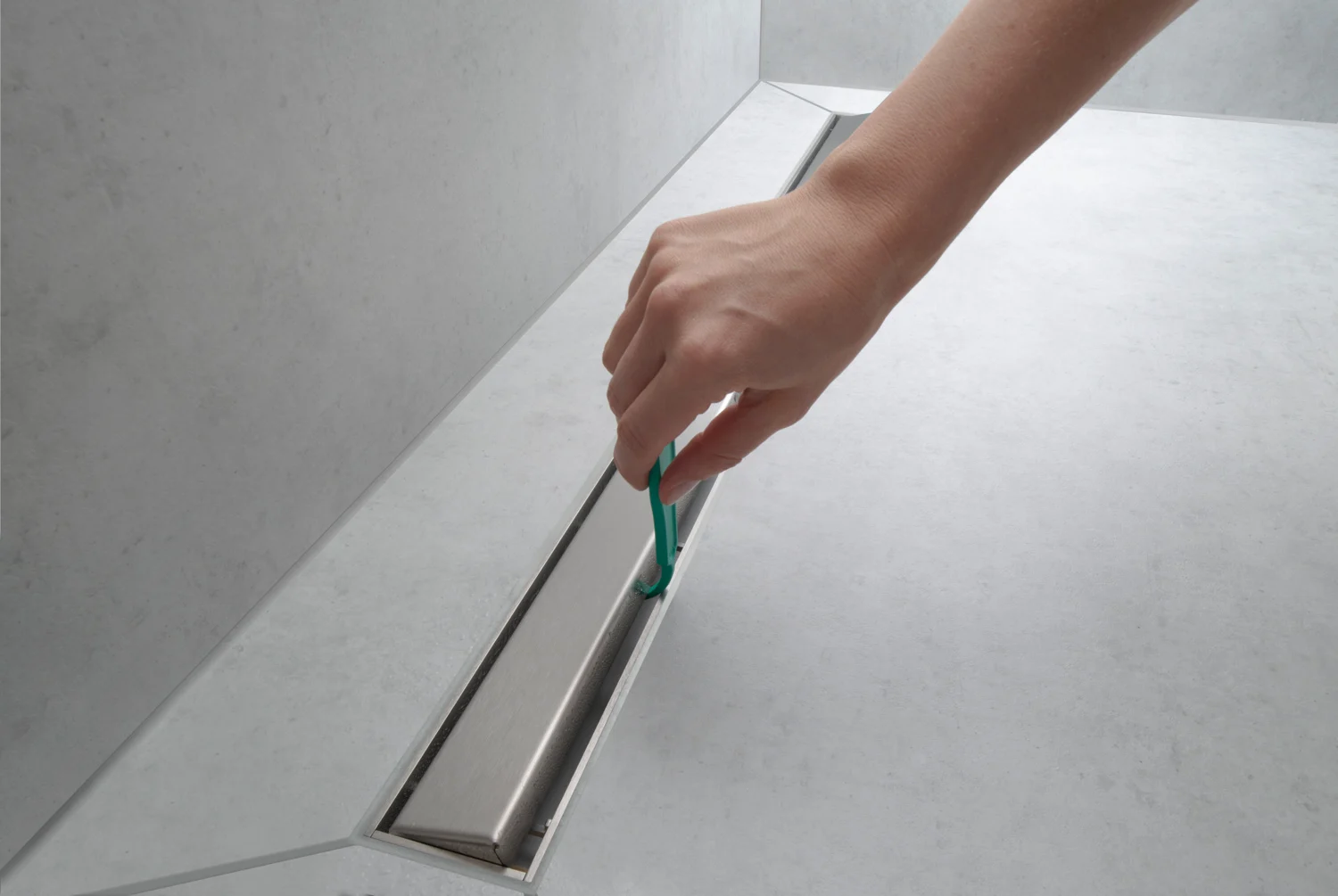 Ręka zdejmująca pokrywę z otworu odpływu prysznicowego, hansgrohe