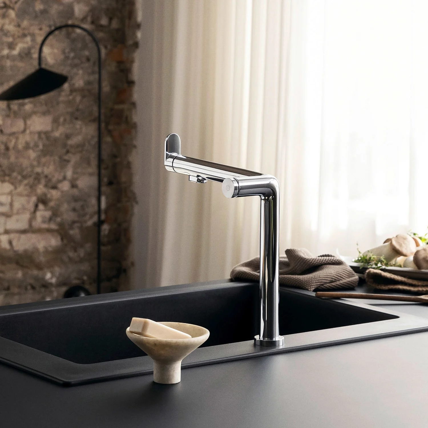 Chromowana bateria kuchenna przy czarnym zlewie, hansgrohe
