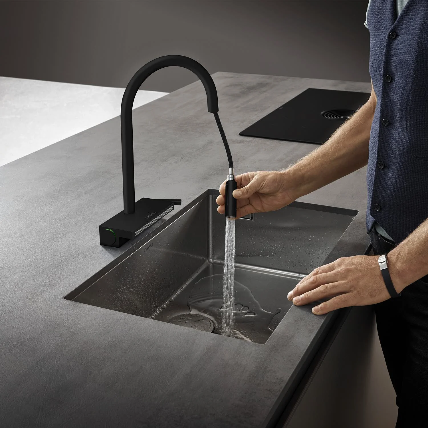Osoba używająca czarnego kranu kuchennego, hansgrohe