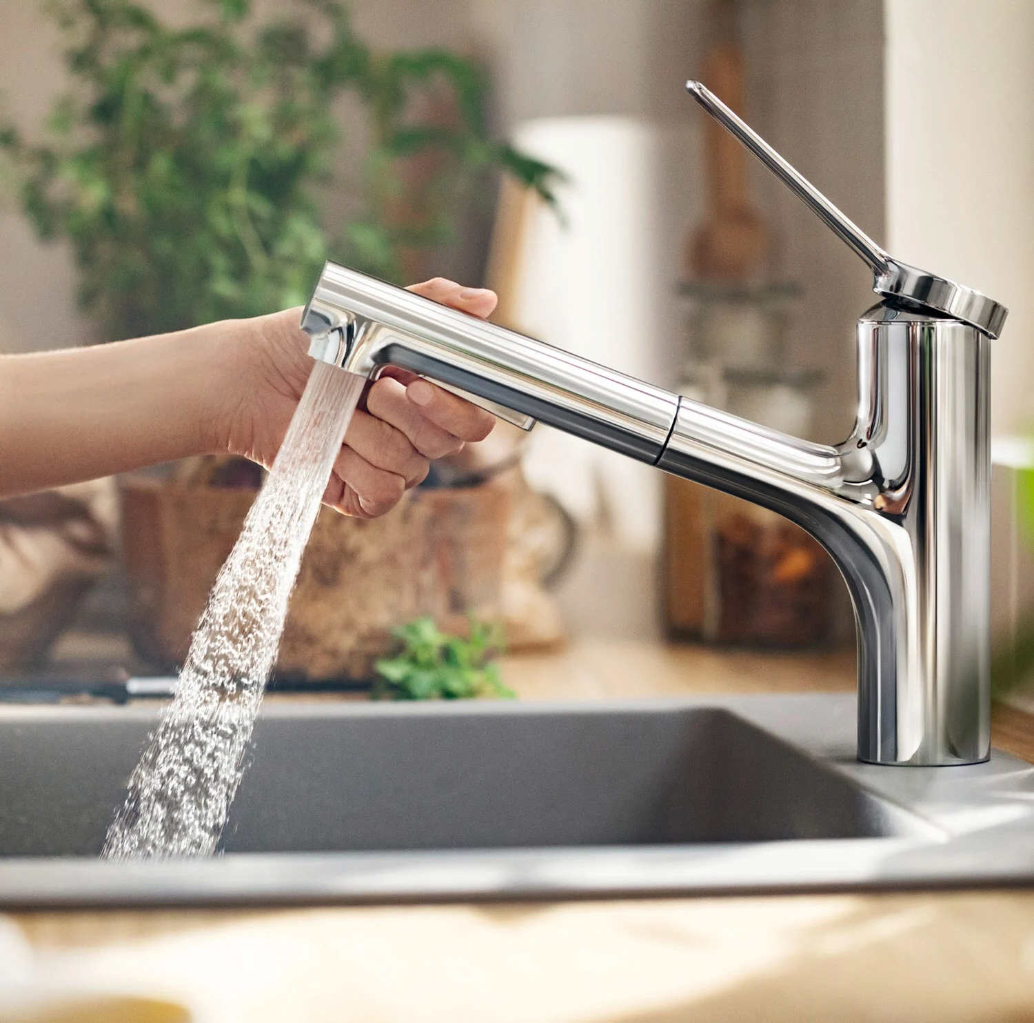 Ręka obsługująca baterię kuchenną z wodą, hansgrohe