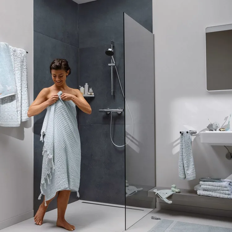 Kobieta w łazience z prysznicem i ręcznikiem, hansgrohe