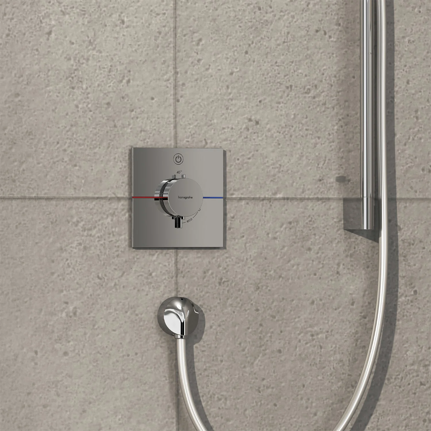 Chromowana armatura prysznicowa na szarej ścianie z płytek, hansgrohe