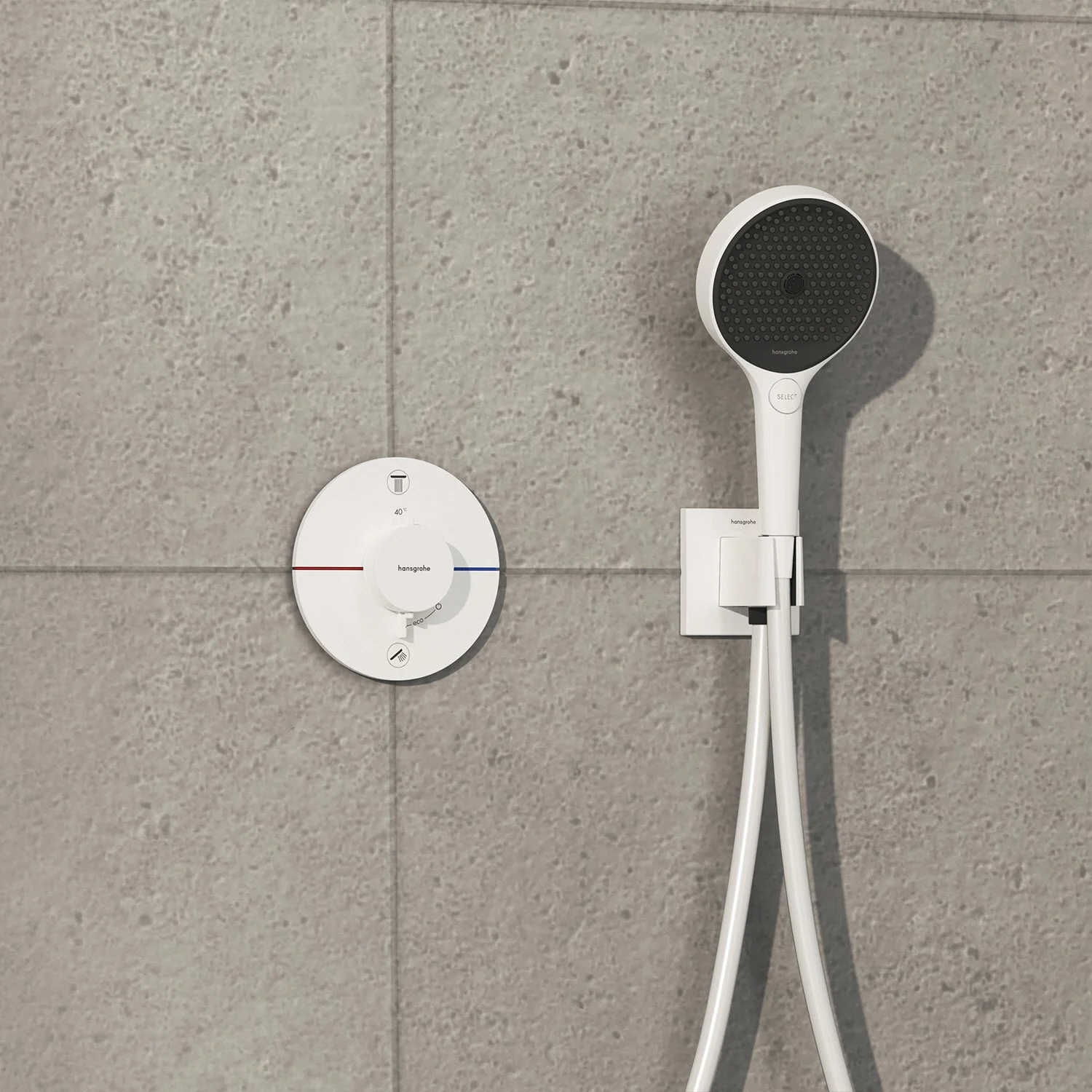 Biała armatura prysznicowa na szarej ścianie z płytek, hansgrohe