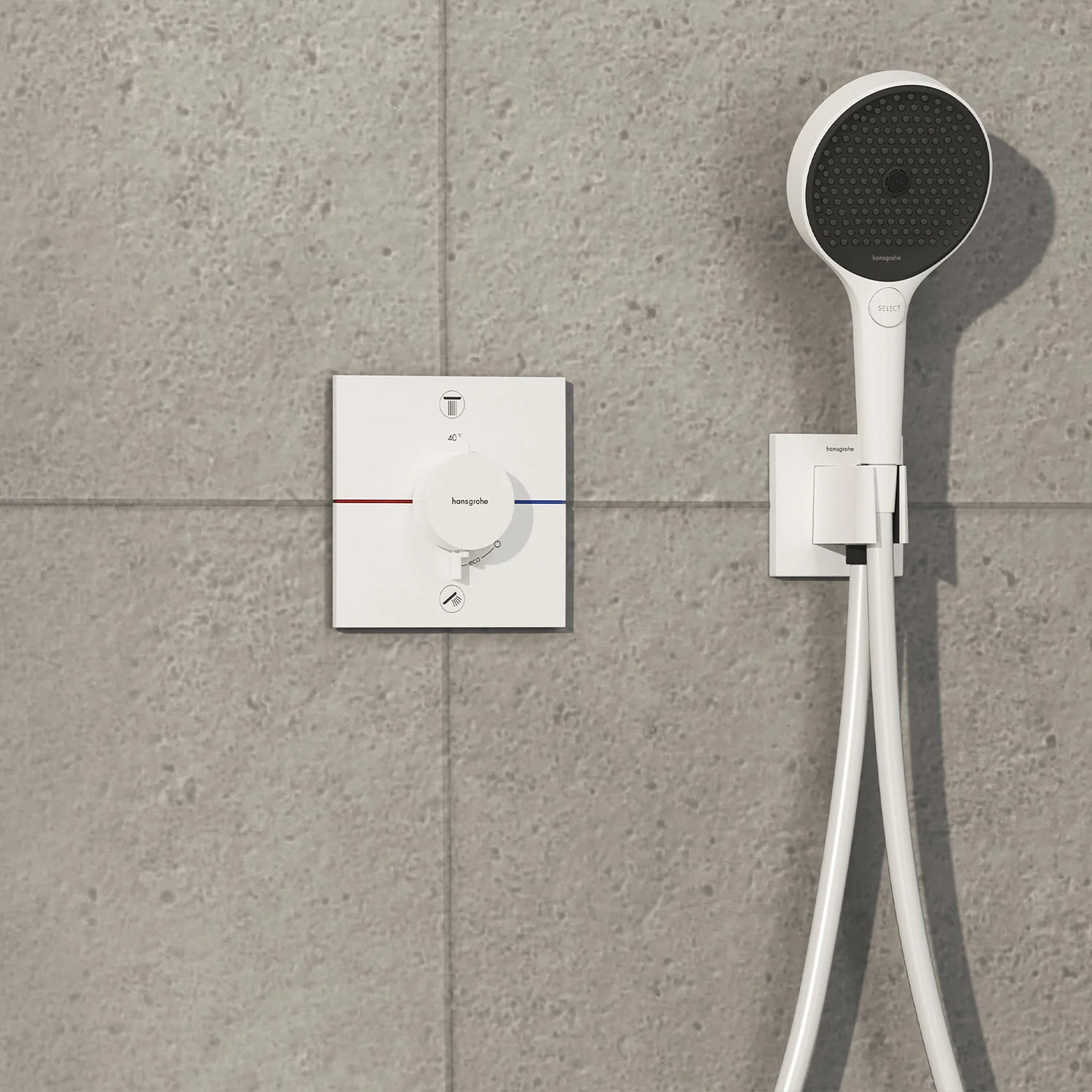 Biała armatura prysznicowa na szarej ścianie z płytek, hansgrohe