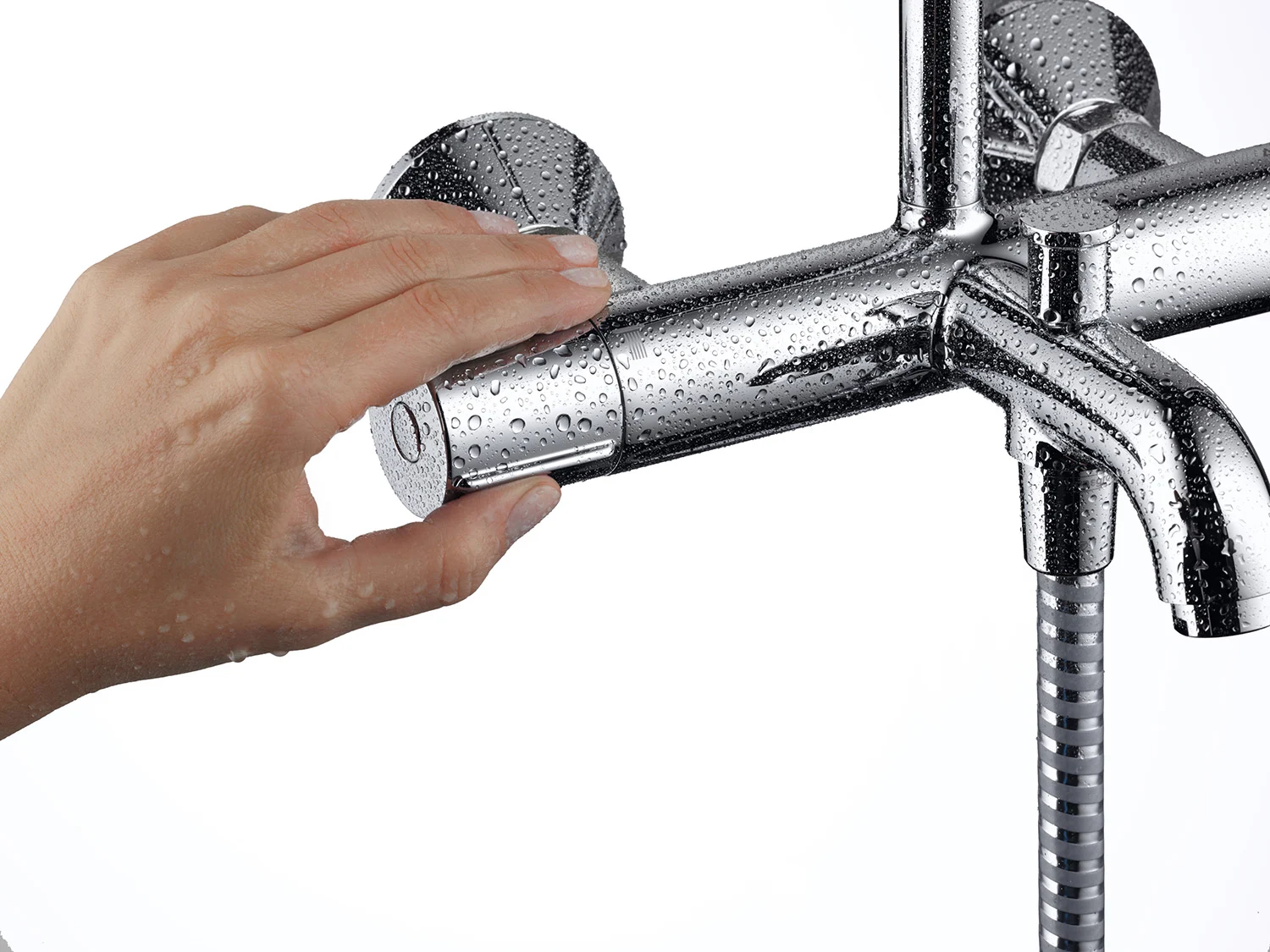 Ręka reguluje chromowany system prysznicowy z kroplami wody, hansgrohe