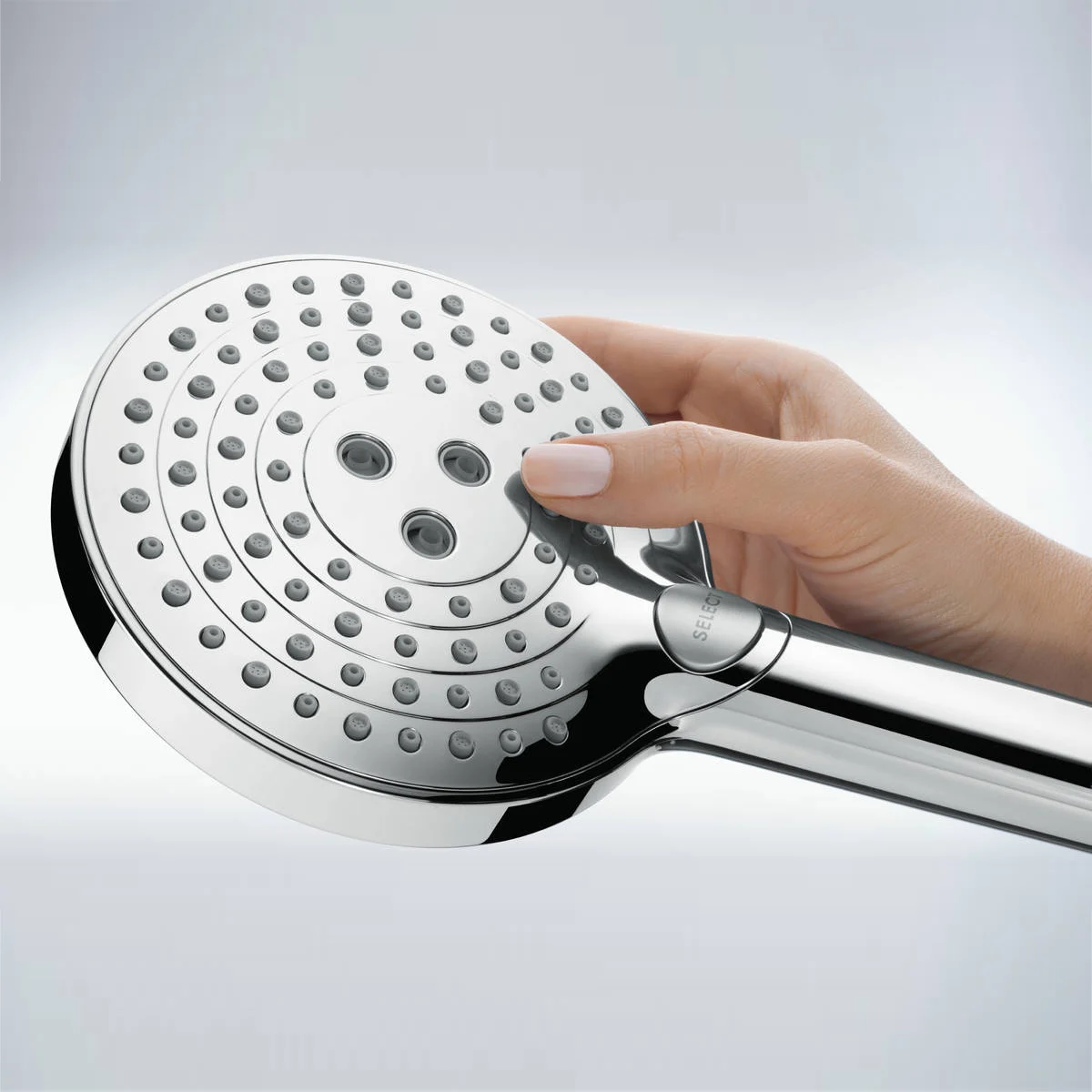 Ręka trzyma chromowaną słuchawkę prysznicową, hansgrohe