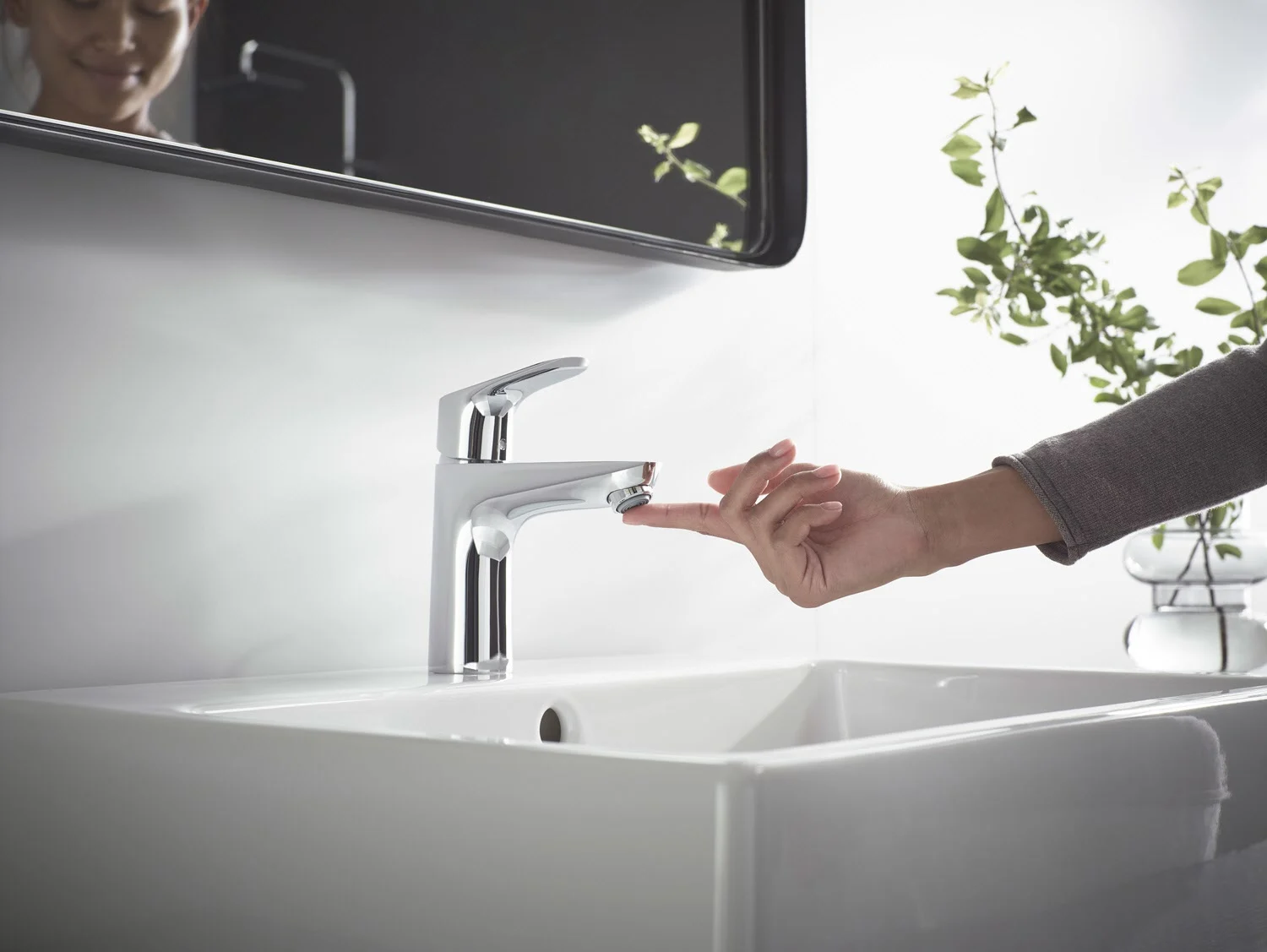 Ręka obsługuje baterię jednouchwytową przy umywalce, hansgrohe