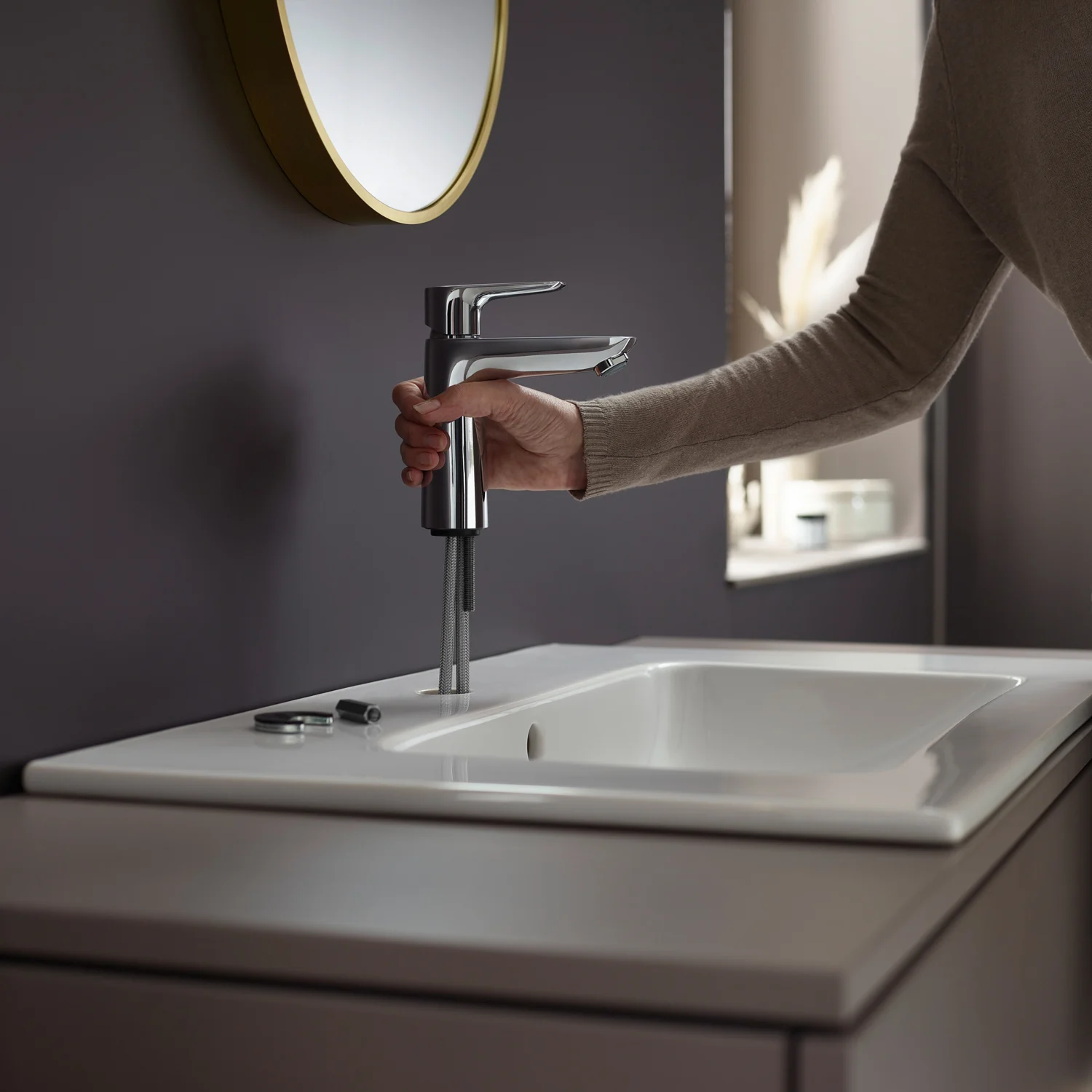 Osoba używająca jednouchwytowej baterii umywalkowej, hansgrohe