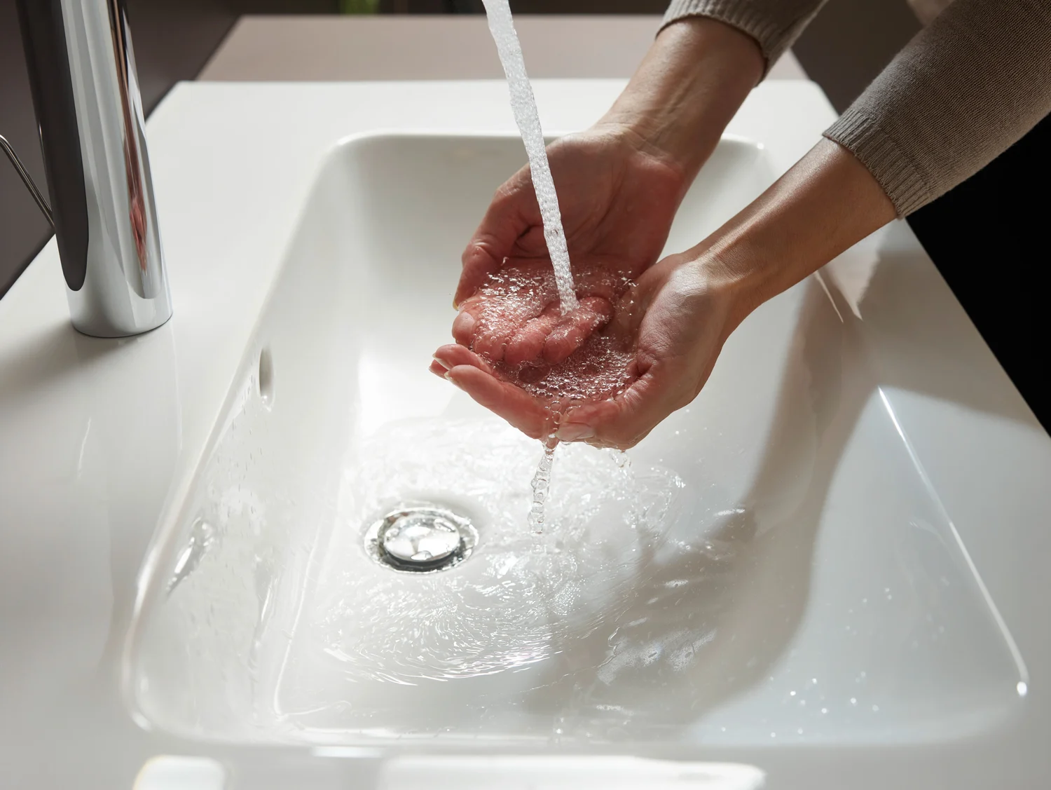 Ręce pod bieżącą wodą w umywalce, hansgrohe