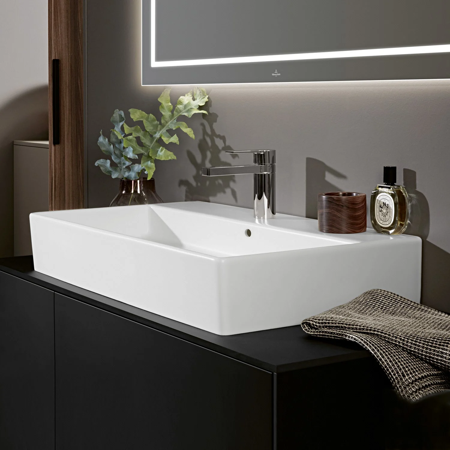 Biała umywalka z baterią na czarnej szafce, Villeroy & Boch