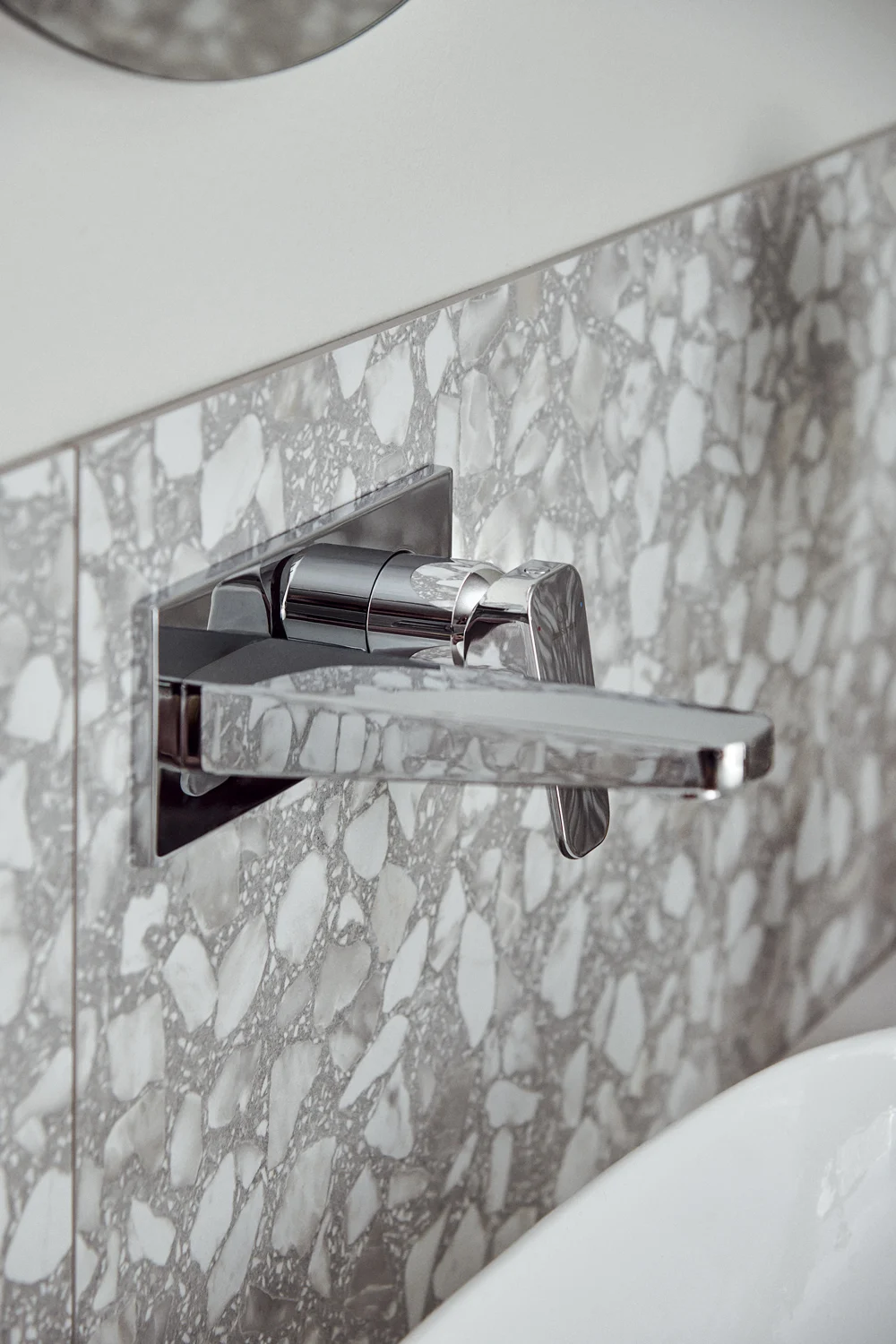 Chromowana bateria umywalkowa zamontowana na ścianie z terrazzo, Ideal Standard