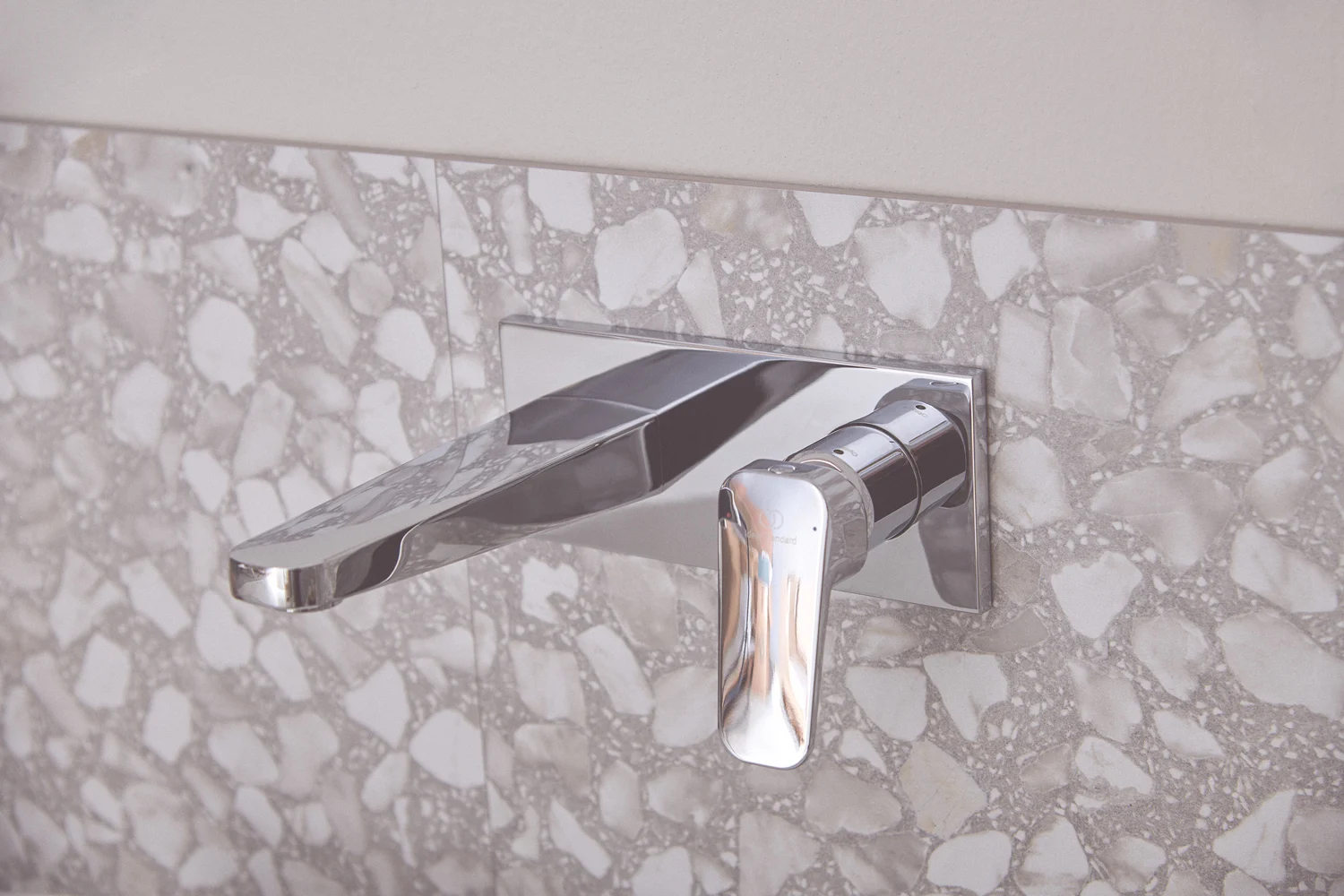 Chromowana bateria umywalkowa zamontowana na ścianie z terrazzo, Ideal Standard