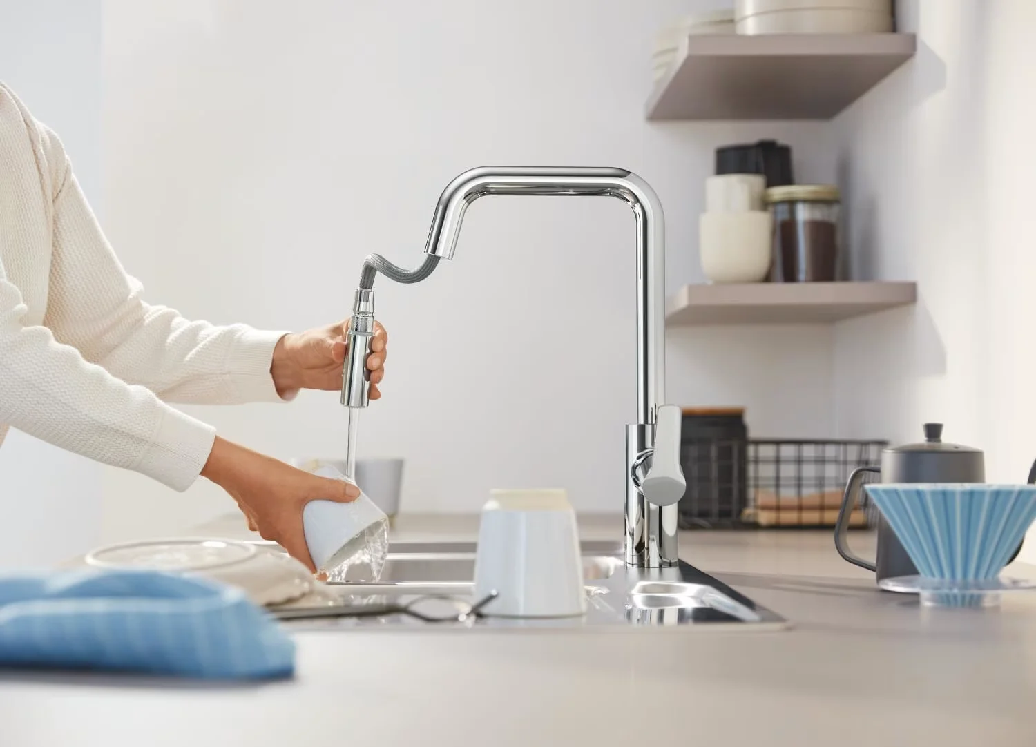 Osoba używająca baterii kuchennej nad zlewem, Grohe