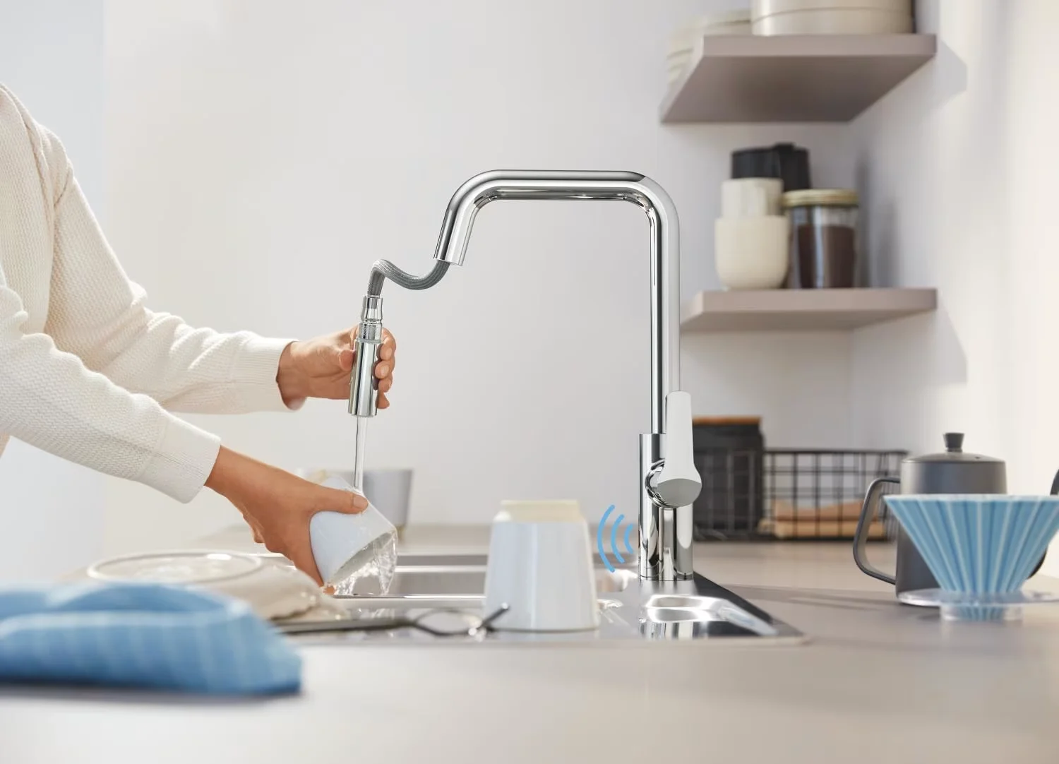 Osoba używająca baterii kuchennej nad zlewem, Grohe