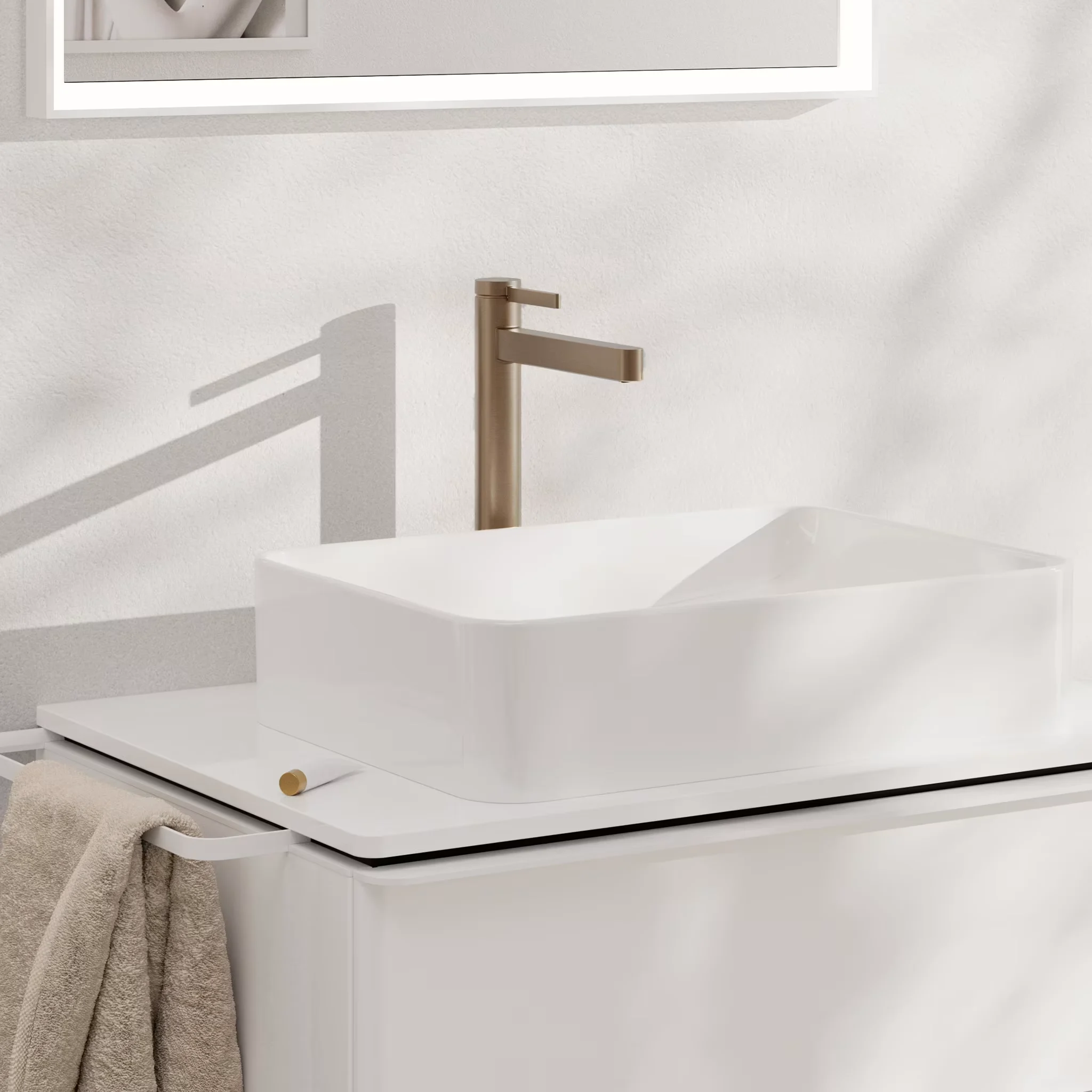 Złota bateria na białej umywalce, hansgrohe