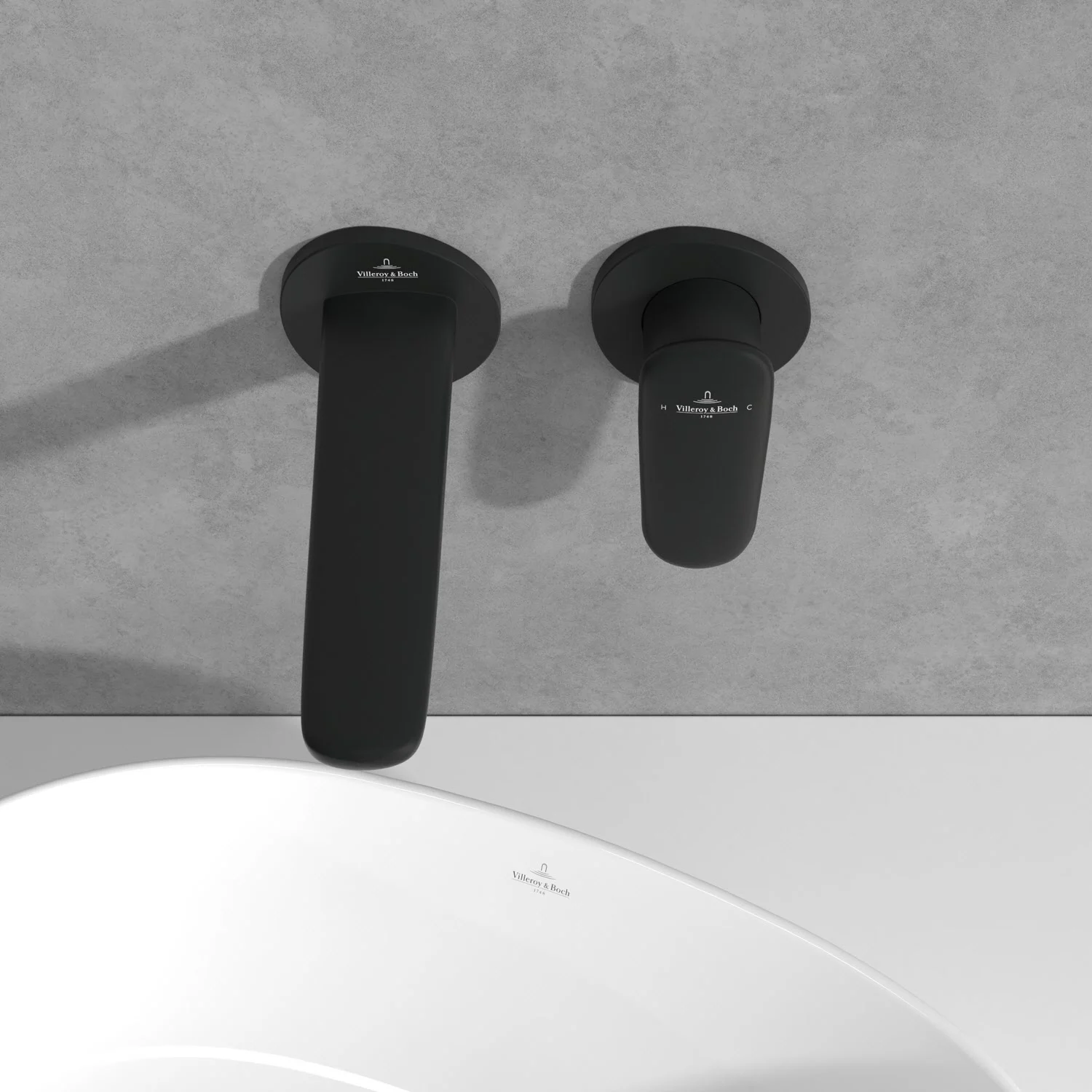 Czarna bateria ścienna nad białą umywalką, Villeroy & Boch